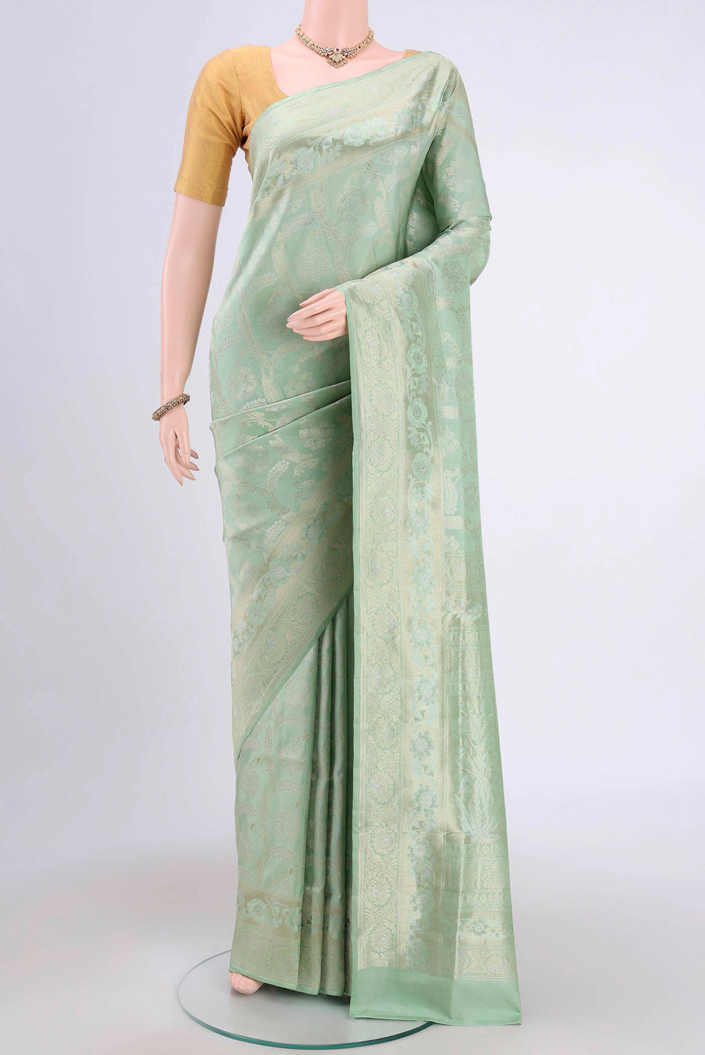 Mint Green Soft Silk Saree with Zari Brocade on the body and Zari Border.  displayed on a mannequin