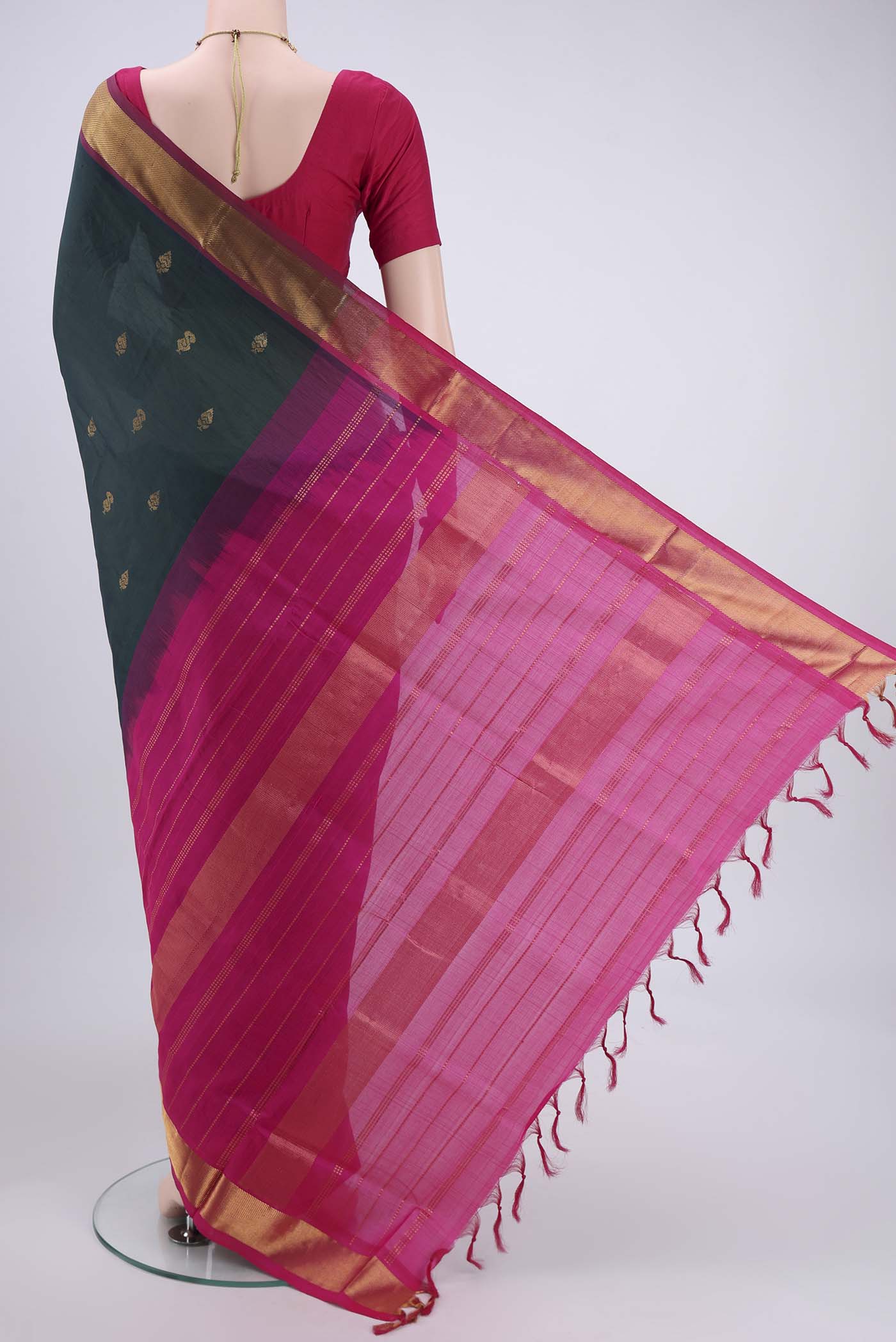 Flat view of Bottle Green Blended Poly Cotton Saree with Zari Butta on the body and Thread Border. 