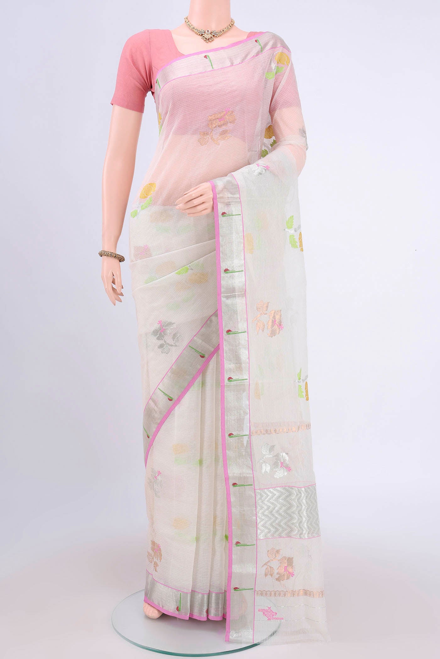 Pure Silk Pure Zari Peach Kota Cotton Saree with Zari And Thread Butta on the body and Zari Border.  displayed on a mannequin