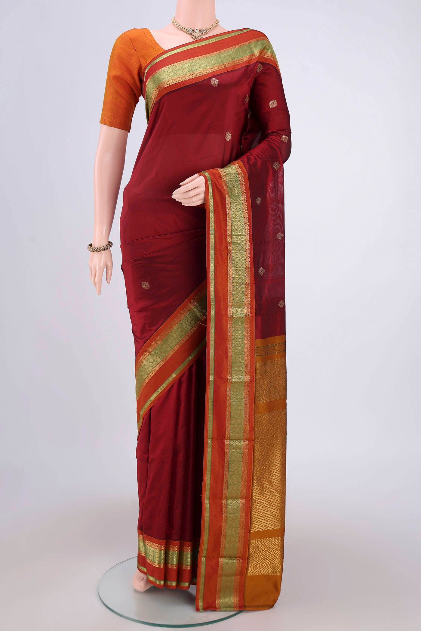 Maroon Blended Bangalore Silk Saree with Zari Butta on the body and Zari Border.  displayed on a mannequin