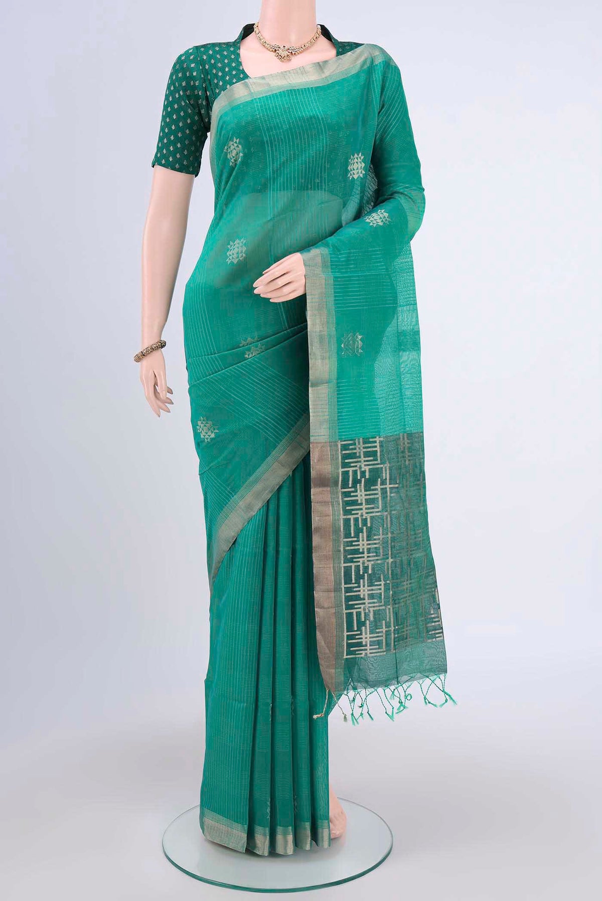 Sea Green Kora Cotton Saree with Zari Butta on the body and Zari Border.  displayed on a mannequin