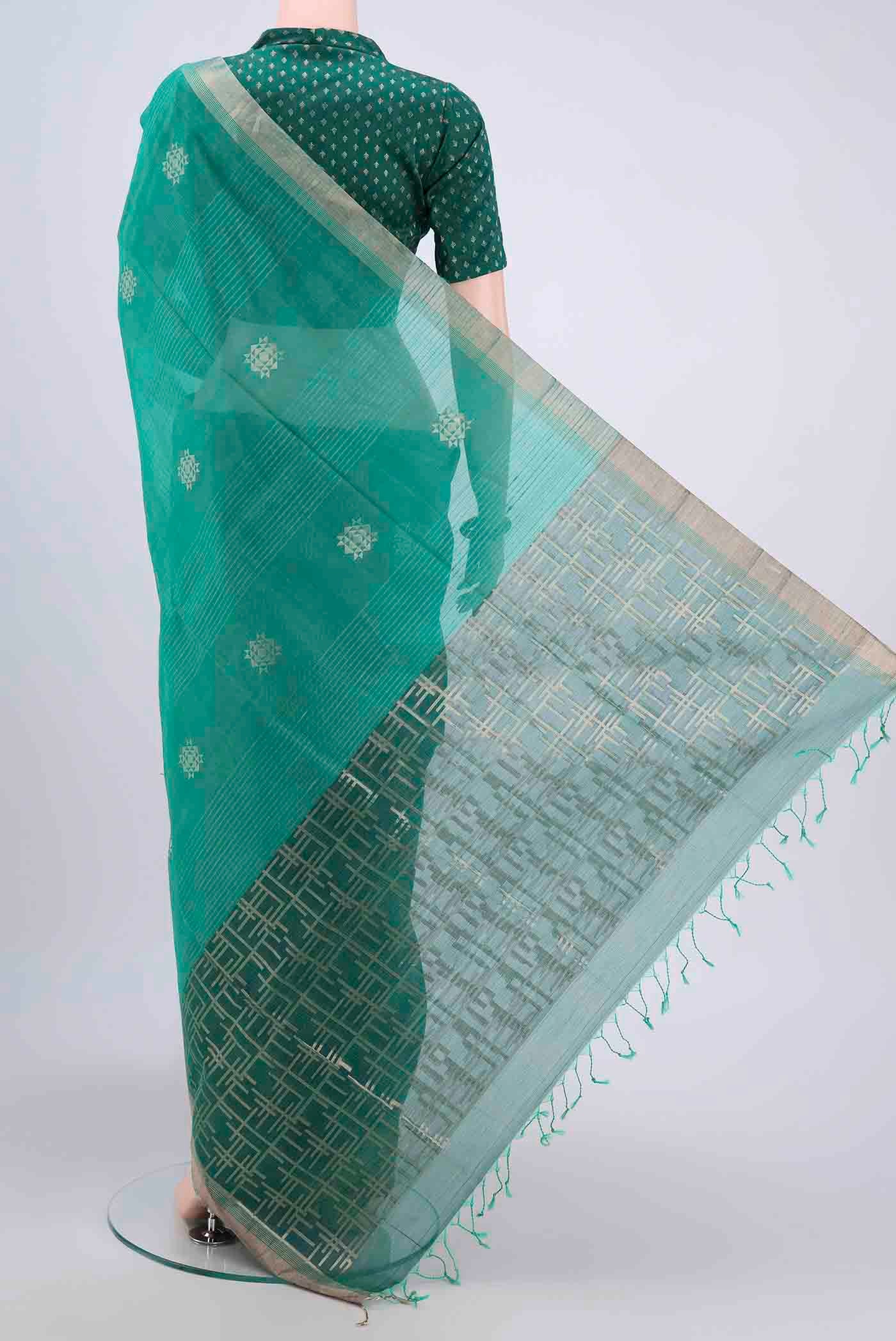 Flat view of Sea Green Kora Cotton Saree with Zari Butta on the body and Zari Border. 