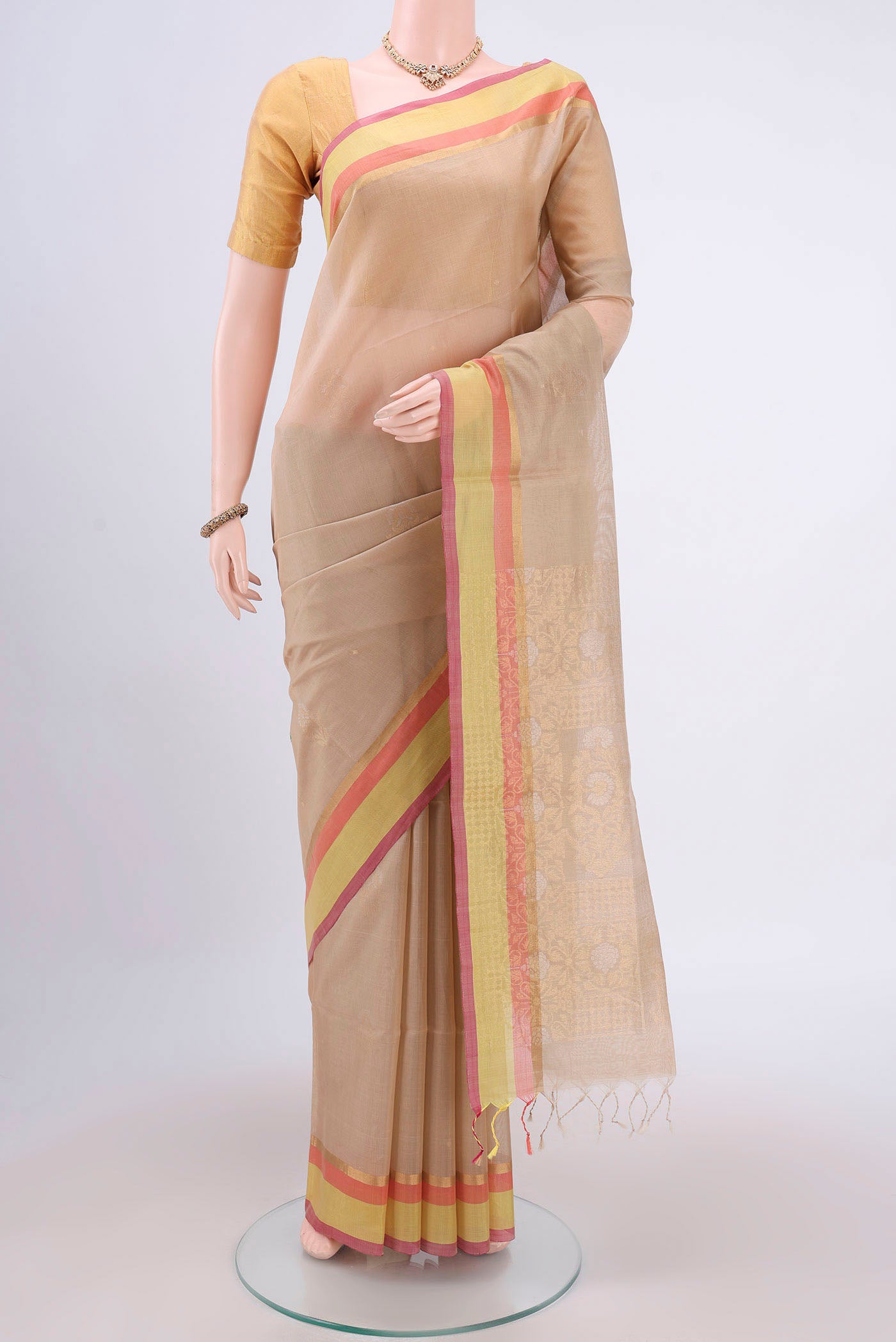 Beige Kora Cotton Saree with Zari Butta on the body and Plain Border.  displayed on a mannequin
