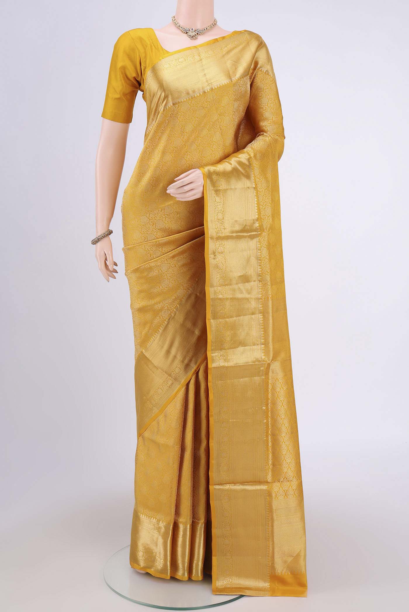 Mustard Soft Silk Saree with Zari Brocade on the body and Zari Border.  displayed on a mannequin