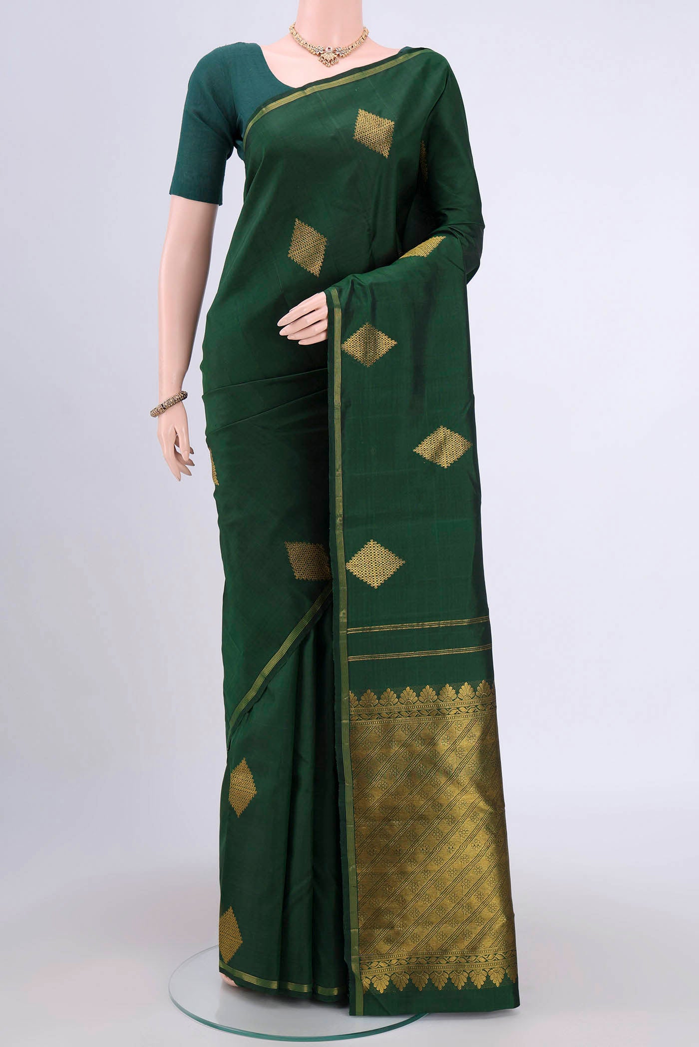 Pure Silk Pure Zari Bottle Green Kanchipuram Saree with Zari Butta on the body and Thin Zari Line.  displayed on a mannequin