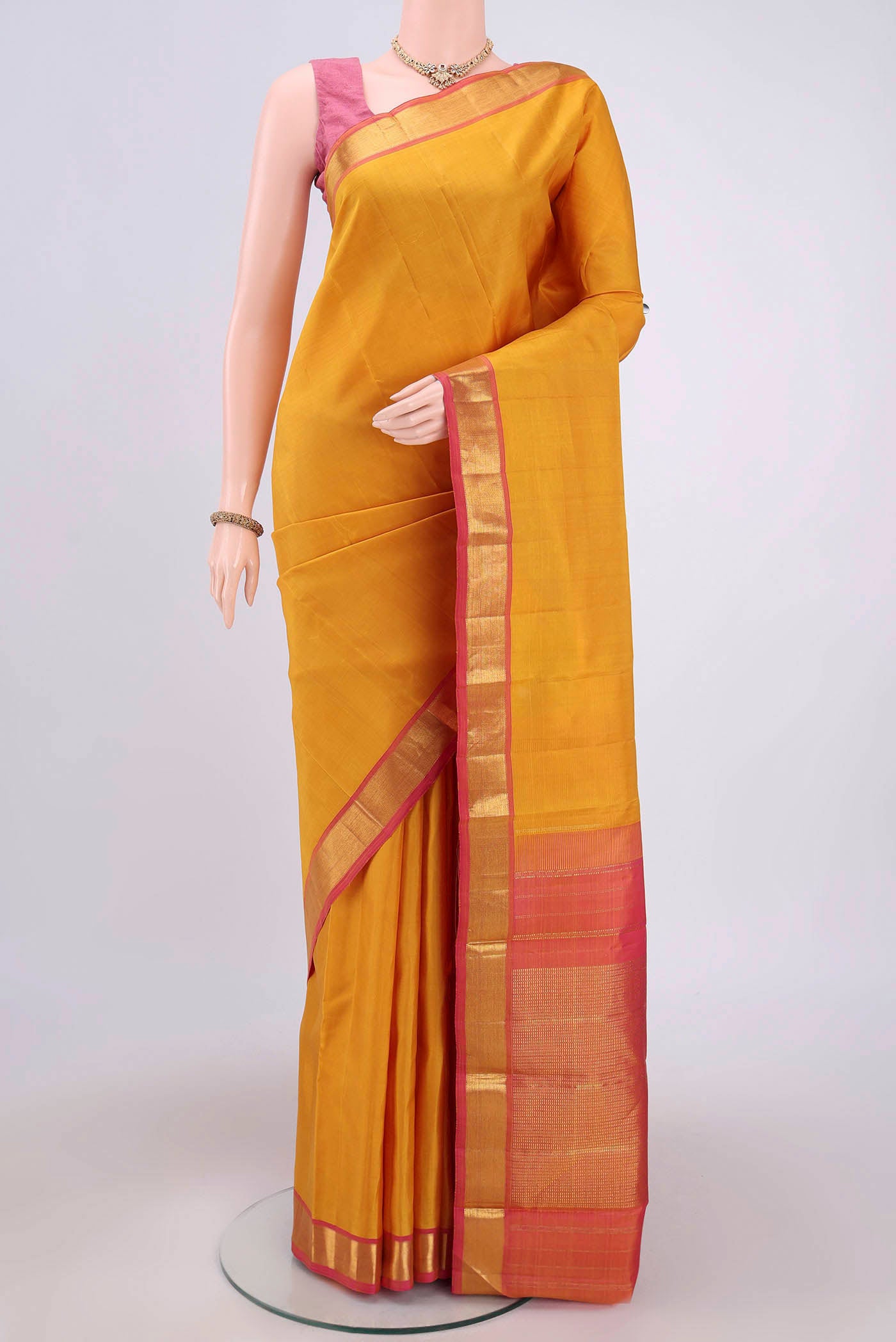 Yellow Kanjivaram Saree with Plain Body and Zari Border.  displayed on a mannequin