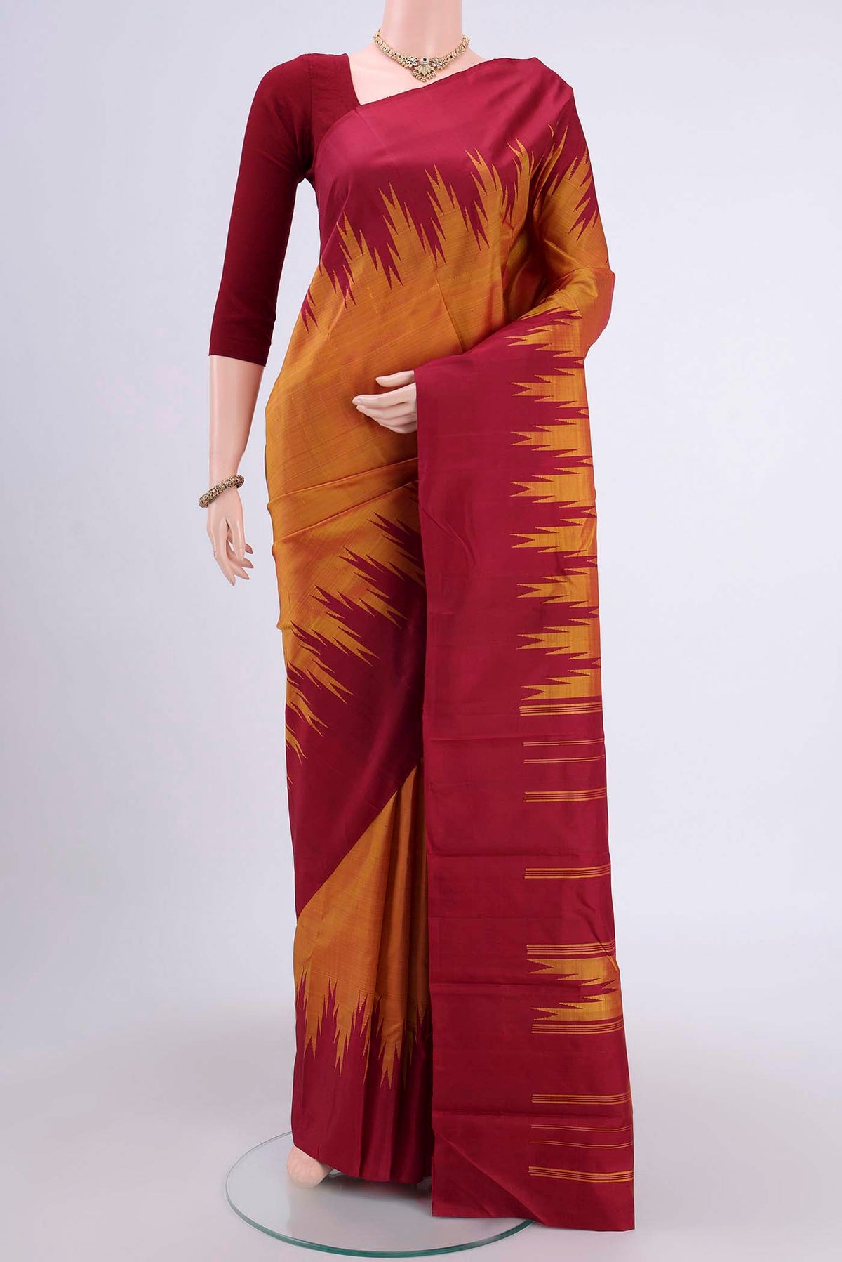 Mustard Kanchipuram Saree with Plain Body and Temple Border displayed on a mannequin
