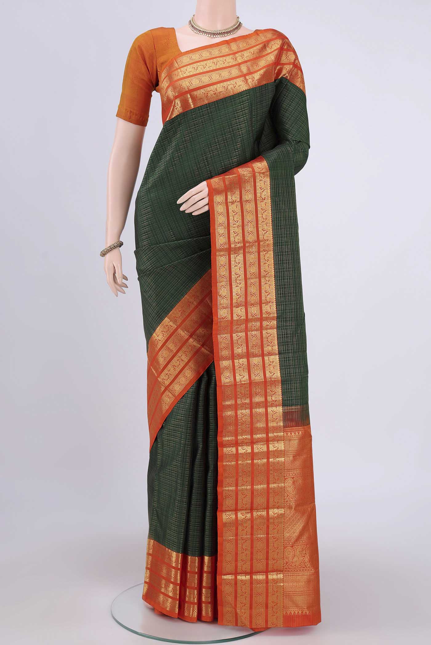 Bottle Green Dual Tone Kanchipuram Saree with Checked design on the body and Zari Border.  displayed on a mannequin