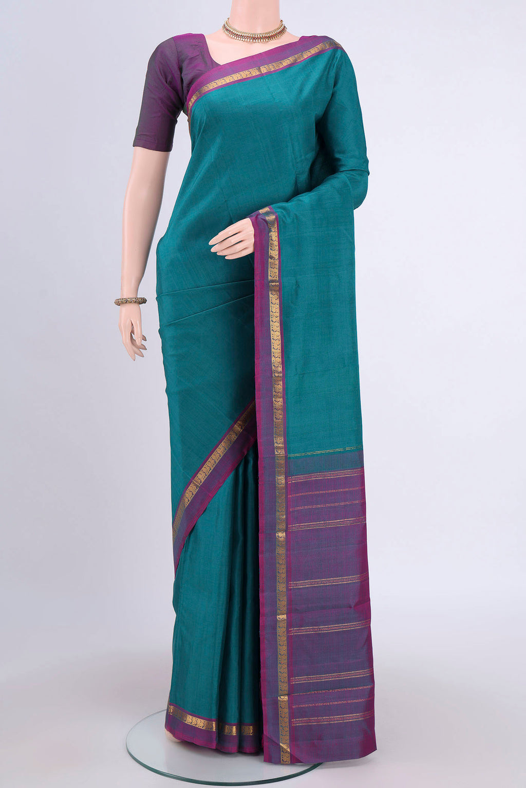 Sea Green Kanjivaram Silk Saree with Plain Body and Zari Border.  displayed on a mannequin