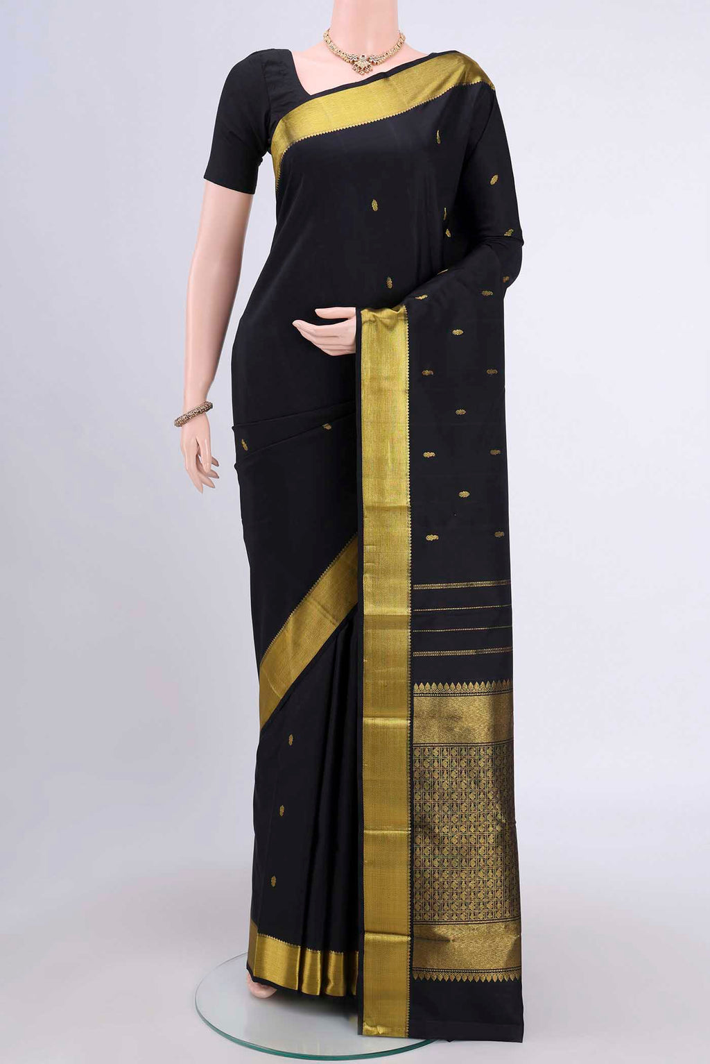 Black Kanchipuram Saree with Zari Butta on the body and Zari Border.  displayed on a mannequin