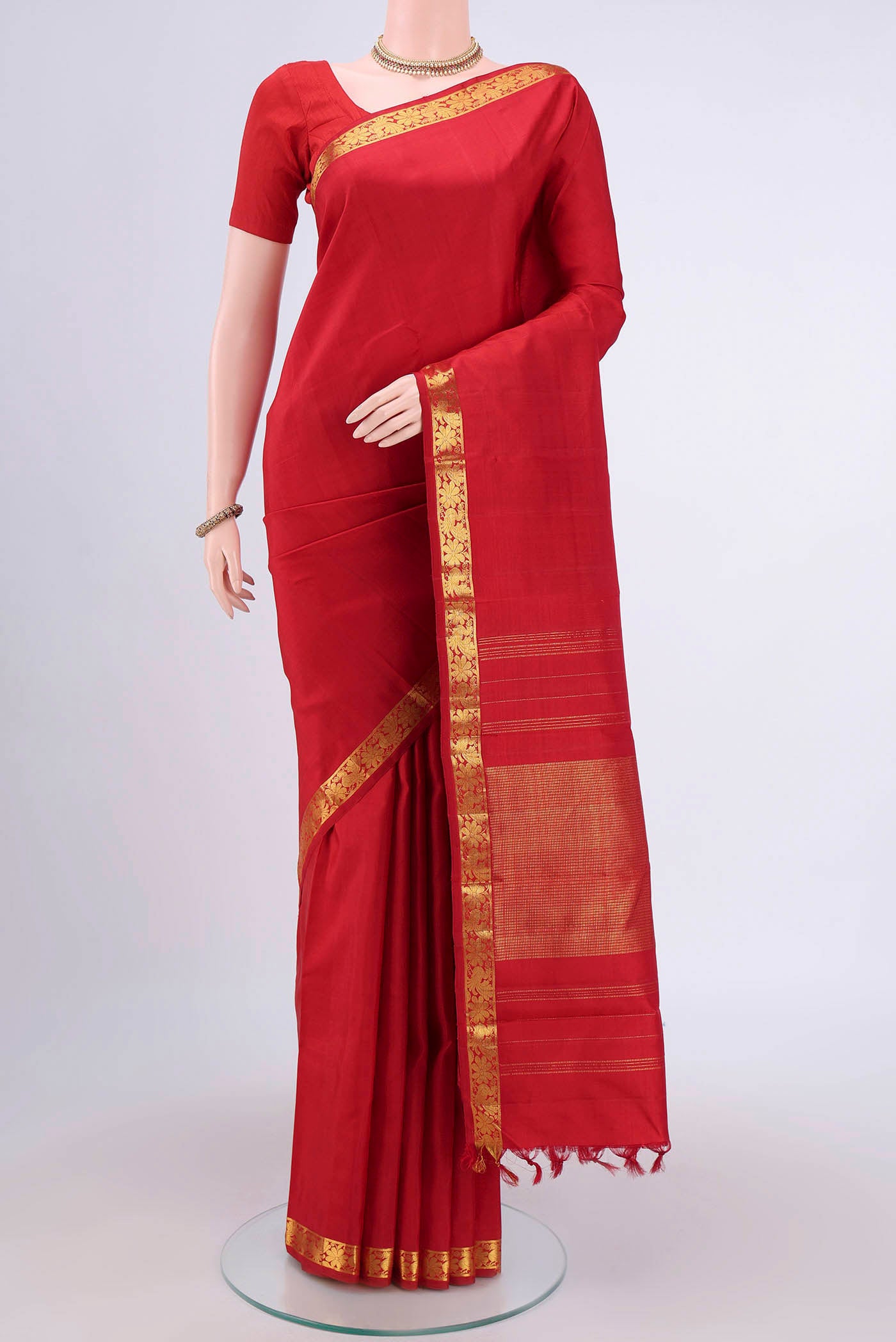 Red Kanjivaram Saree with Plain Body and Zari Border.  displayed on a mannequin