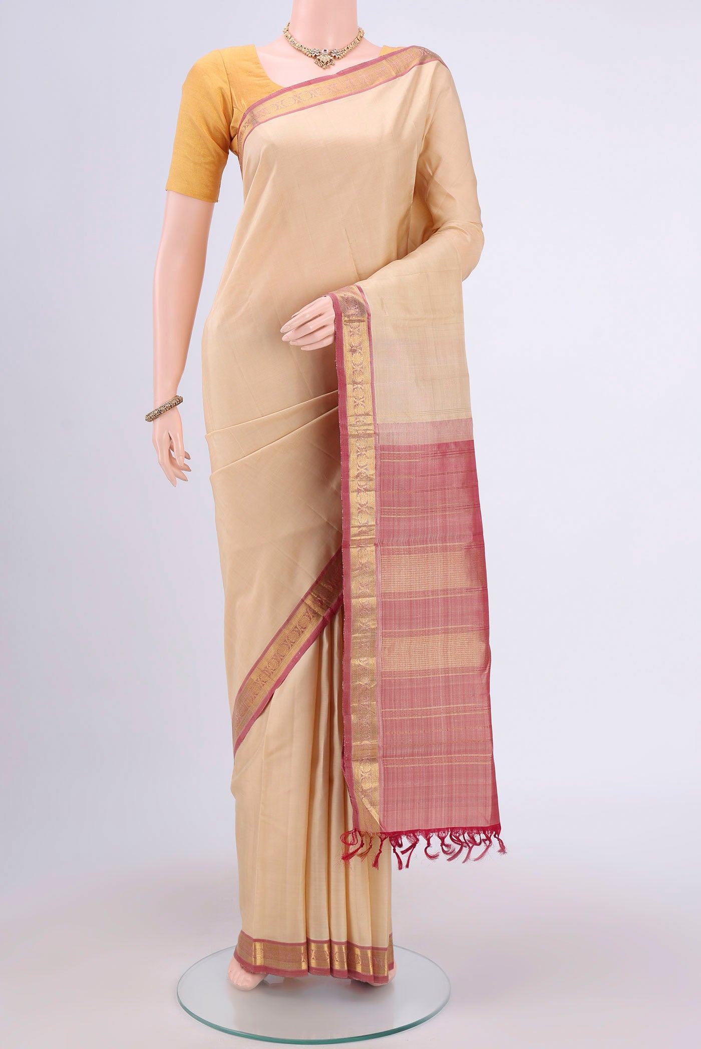 Beige Dual Tone Kanjivaram Saree with Plain Body and Zari Border.  displayed on a mannequin