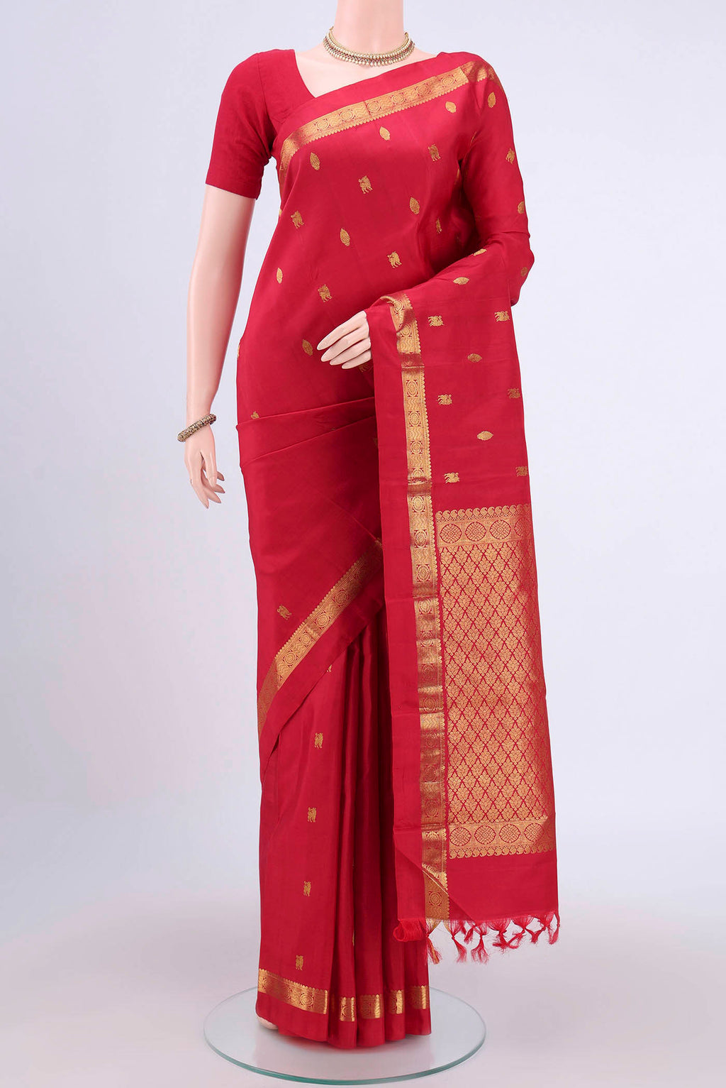 Red Kanchipuram Saree with Zari Butta on the body and Zari Border.  displayed on a mannequin