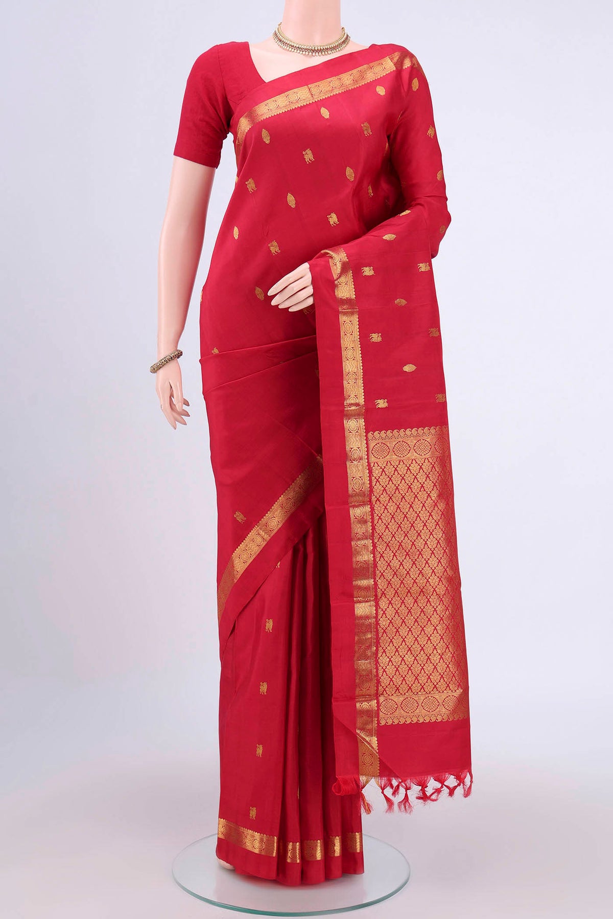 Red Kanchipuram Saree with Zari Butta on the body and Zari Border.  displayed on a mannequin