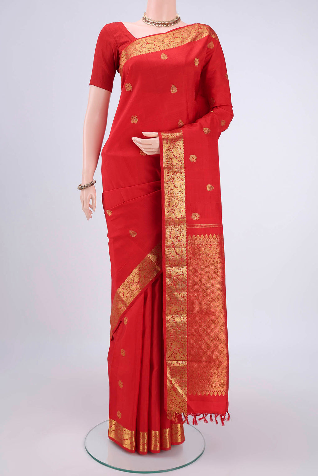 Red Kanjivaram Saree with Zari Butta on the body and Zari Border.  displayed on a mannequin