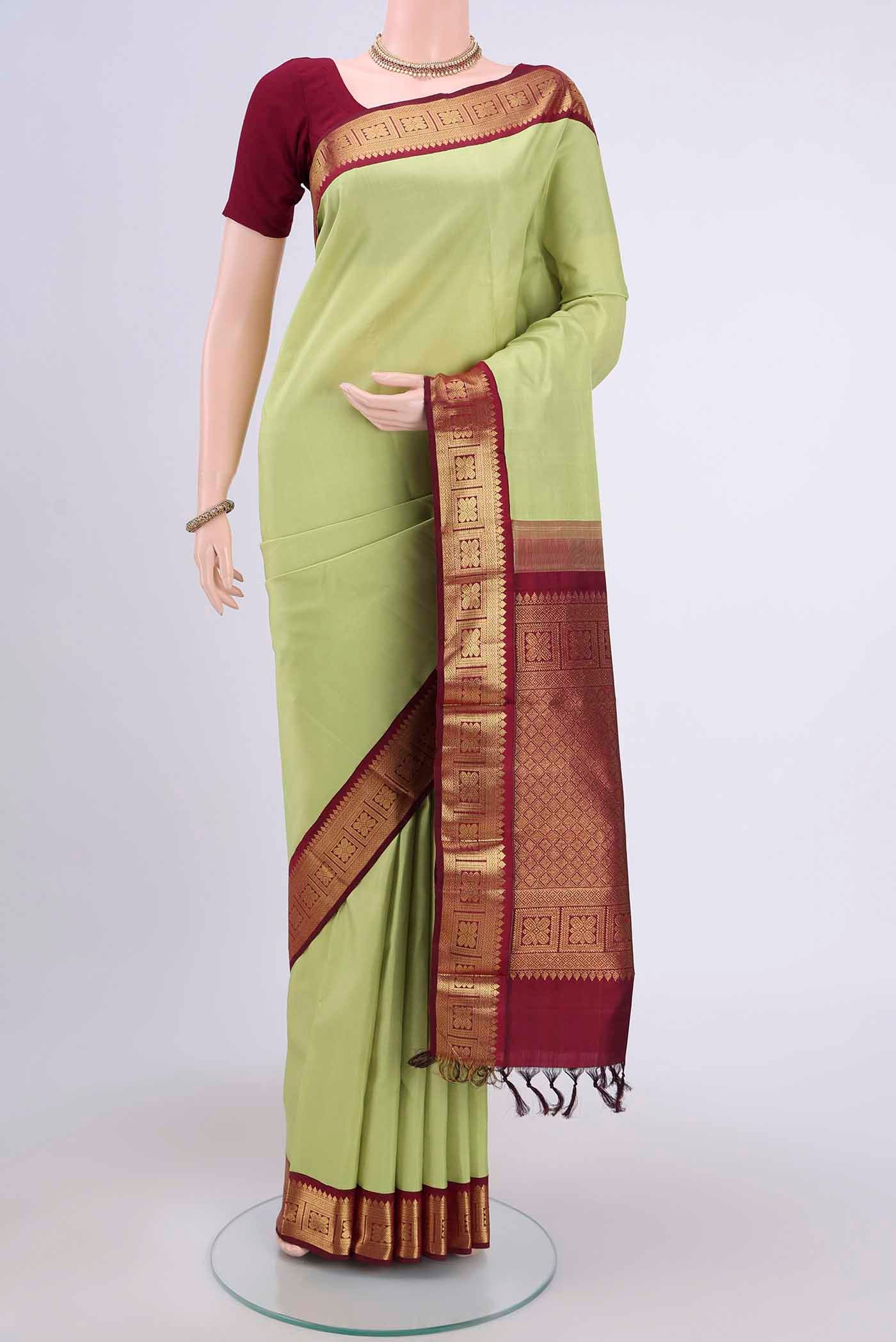 Acid Green Kanjivaram Saree with Plain Body and Zari Border.  displayed on a mannequin