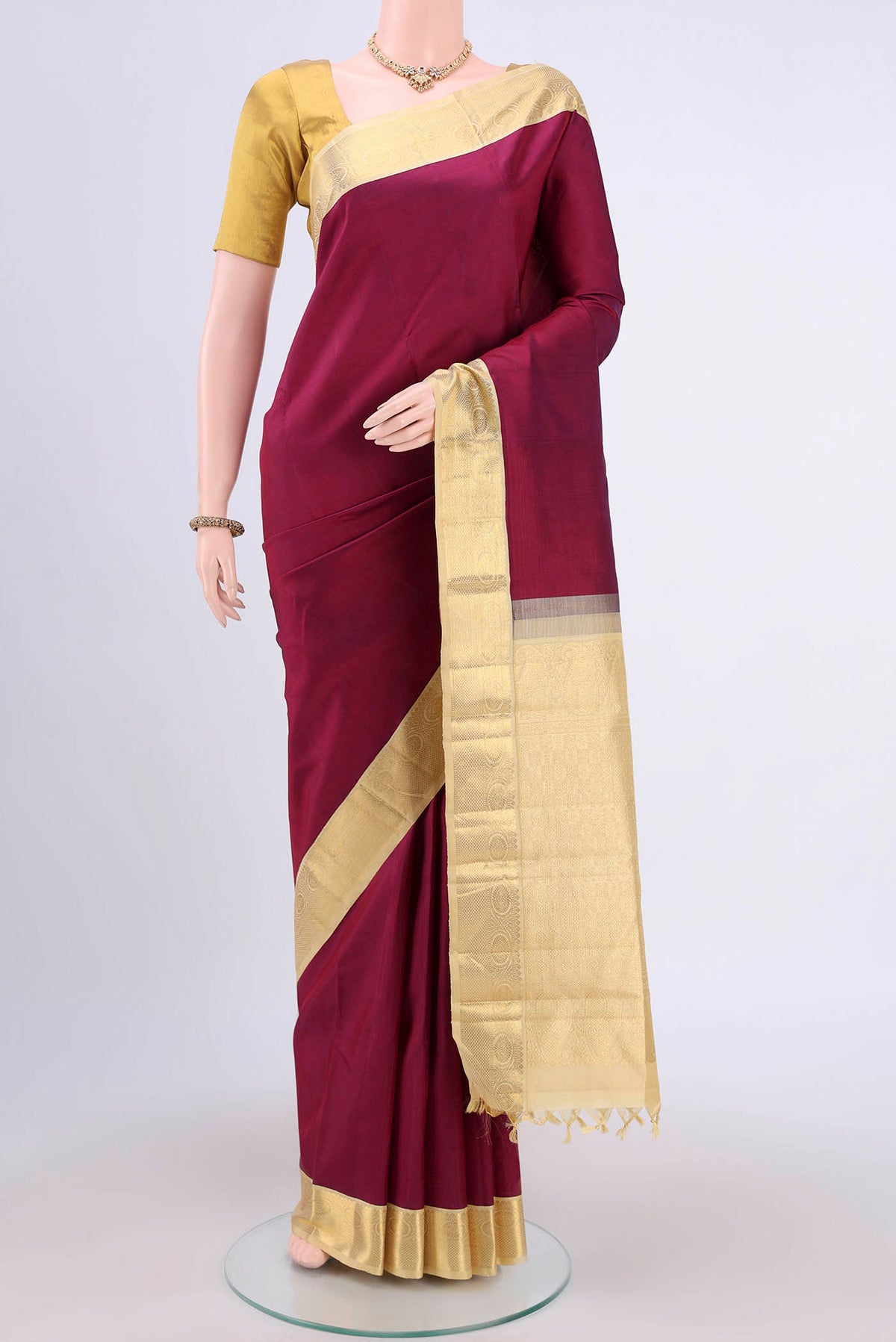 Burgundy Dual Tone Kanjivaram Saree with Plain Body and Zari Border.  displayed on a mannequin