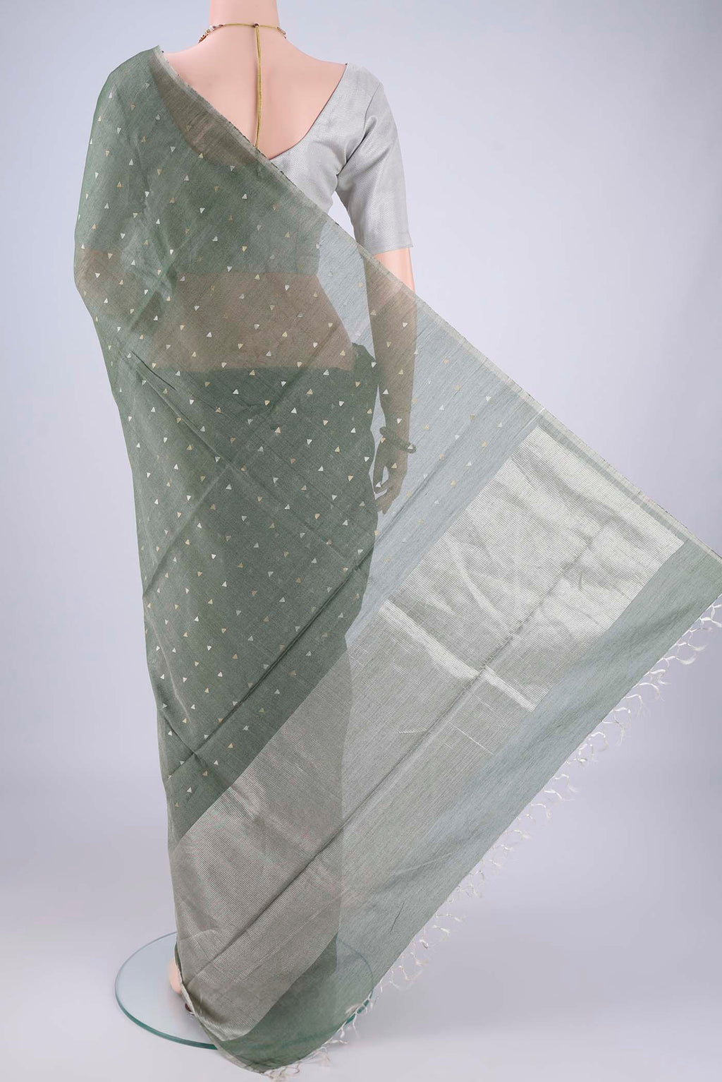 Flat view of Olive Green MP Tussar Saree with Zari Butta on the body and Thin Zari Line. 
