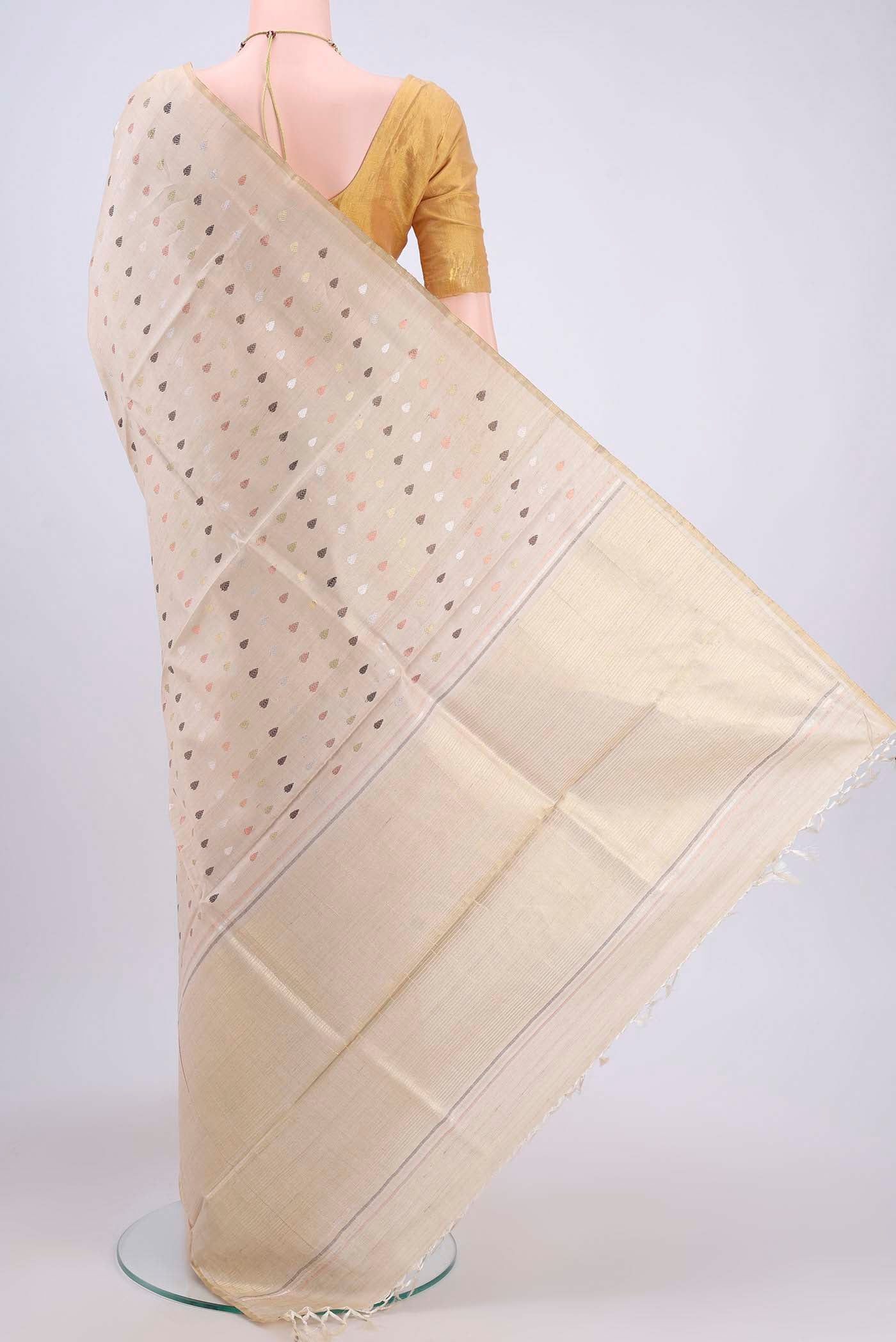 Flat view of Beige Tussar Silk Saree with Zari And Thread Butta on the body and Thin Zari Line. 