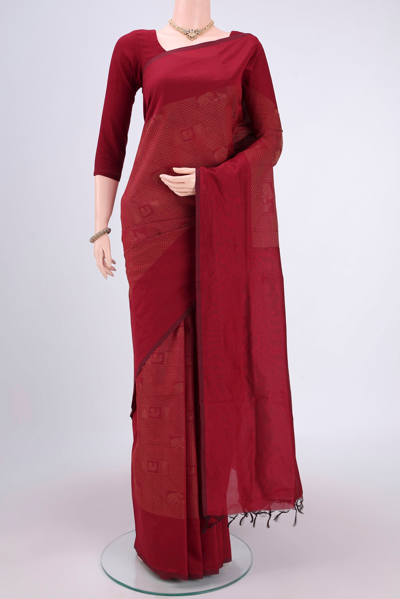 Maroon Blended Poly Cotton Saree with Jacquard design on the body and Plain Border.  displayed on a mannequin