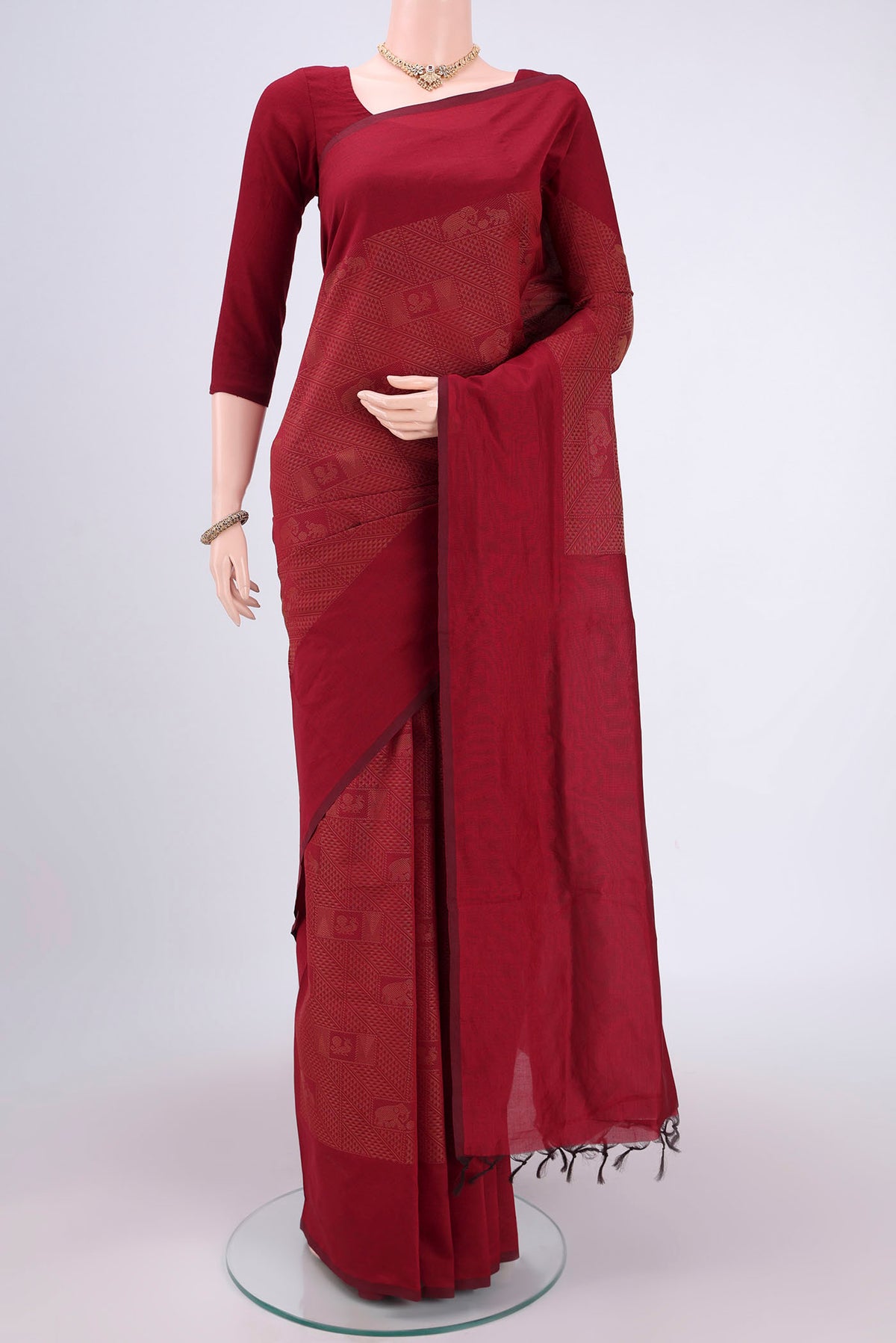 Maroon Blended Poly Cotton Saree with Jacquard design on the body and Plain Border.  displayed on a mannequin