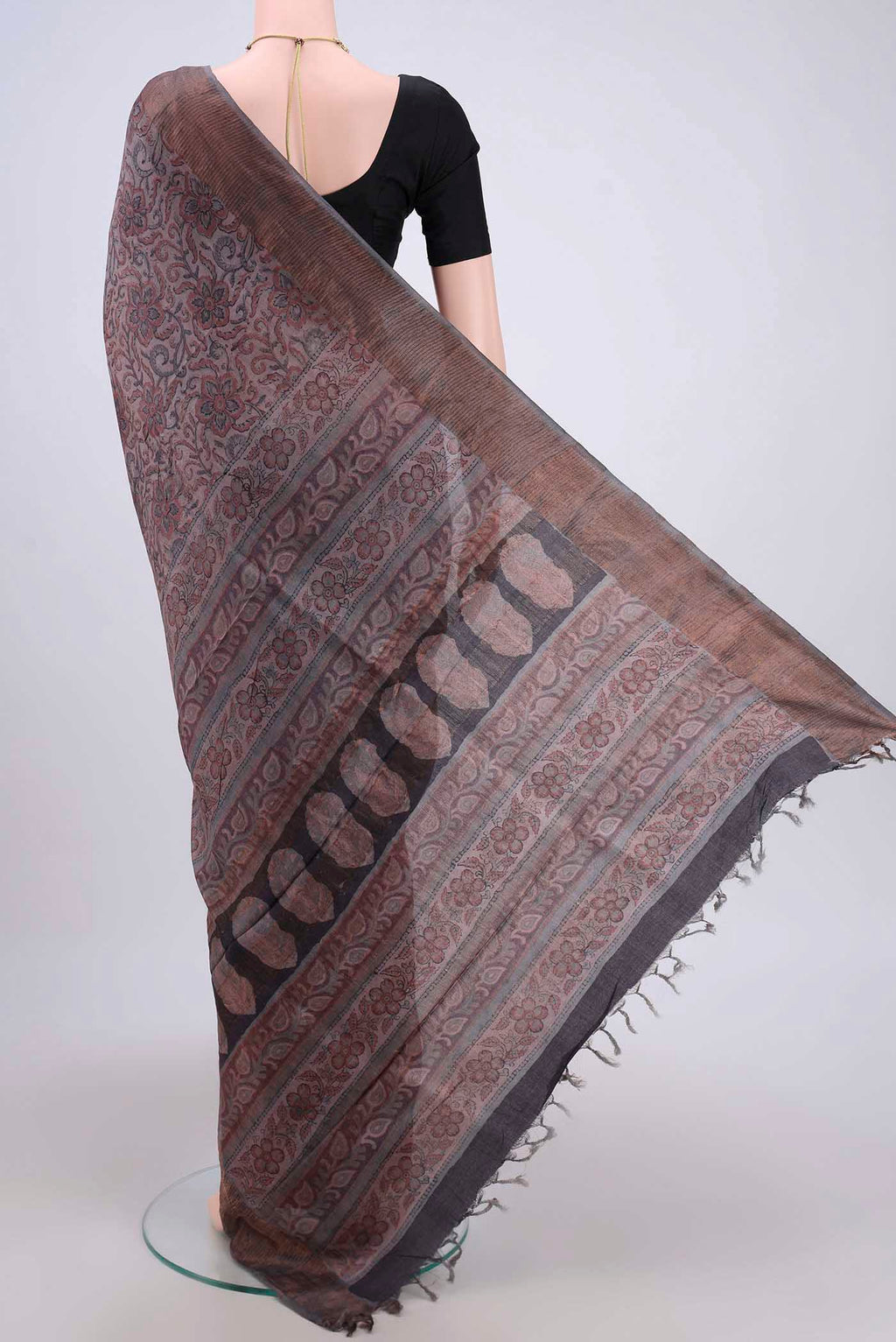 Flat view of Dark Mauve Tussar Silk Saree with kalamkari Print on the body and Zari Border. 