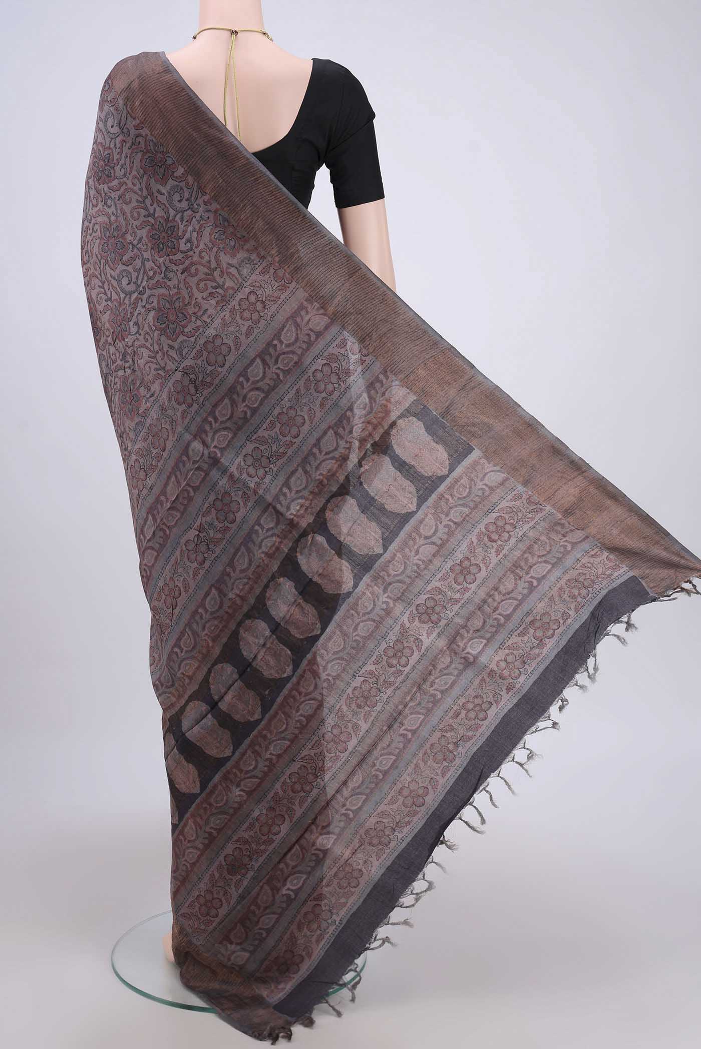 Flat view of Dark Mauve Tussar Silk Saree with kalamkari Print on the body and Zari Border. 