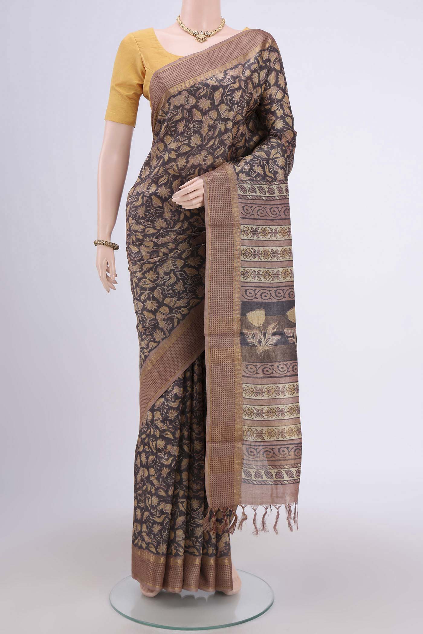 Davys Grey Tussar Silk Saree with kalamkari Print on the body and Zari Border.  displayed on a mannequin