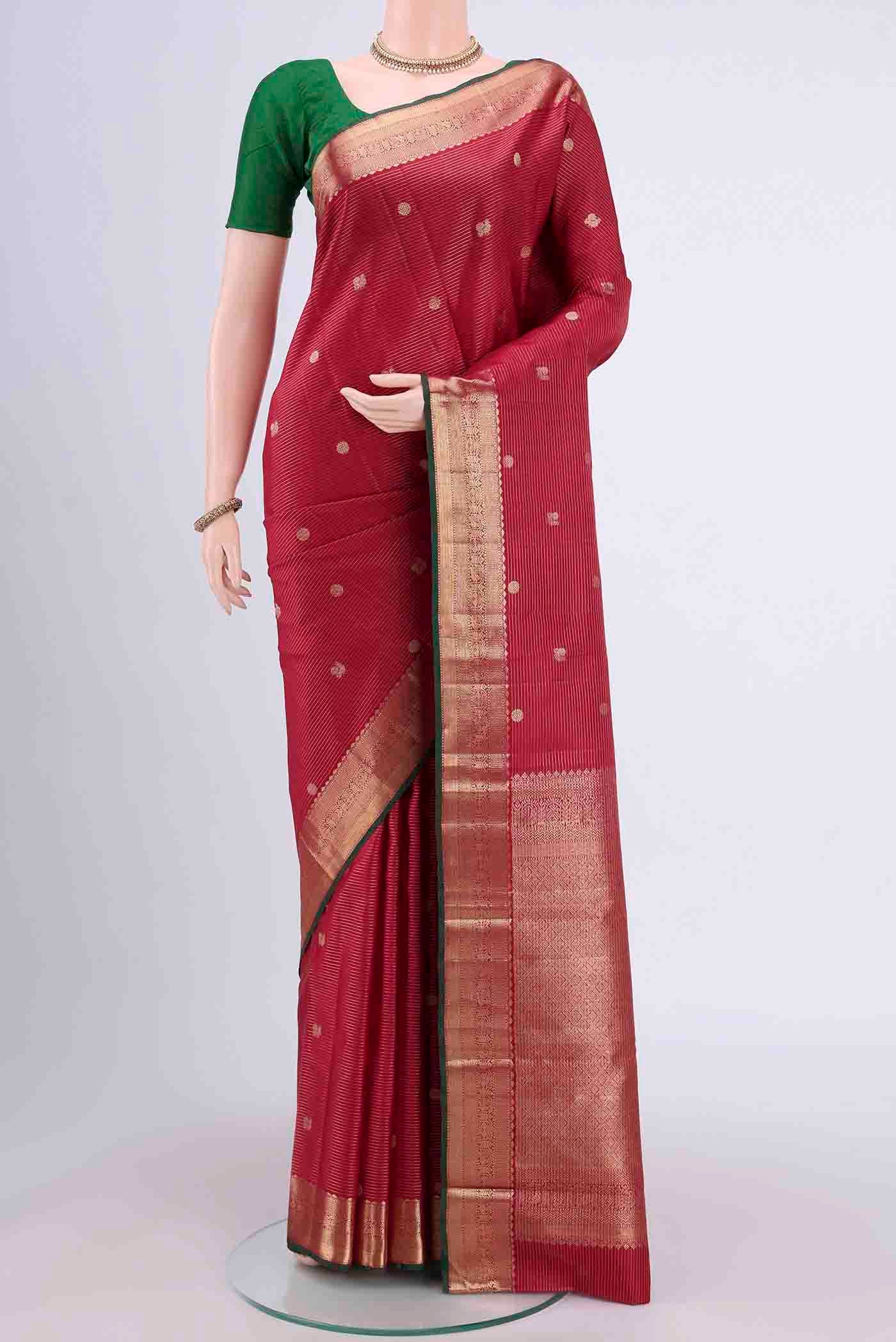 Maroon Kanjivaram Saree with Zari Butta on the body and Zari Border.  displayed on a mannequin
