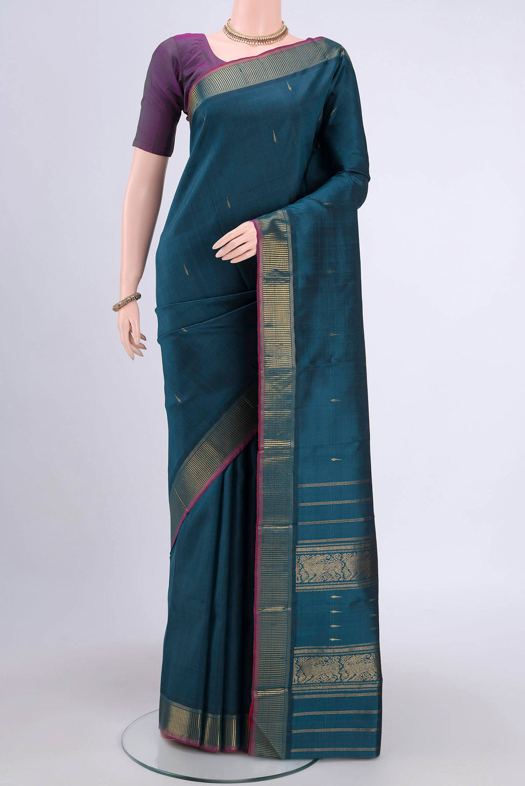 Peacock Blue Kanchipuram Saree with Zari Butta on the body and Zari Border.  displayed on a mannequin