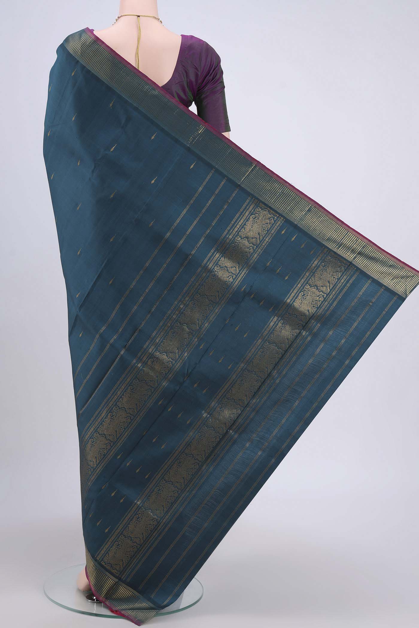 Flat view of Peacock Blue Kanchipuram Saree with Zari Butta on the body and Zari Border. 