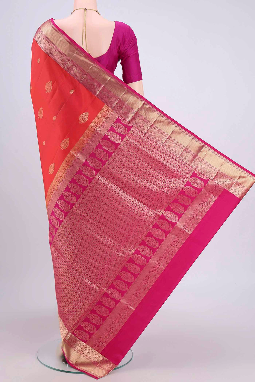 Flat view of Brick Orange Soft Silk Saree with Zari Butta on the body and Zari Border. 