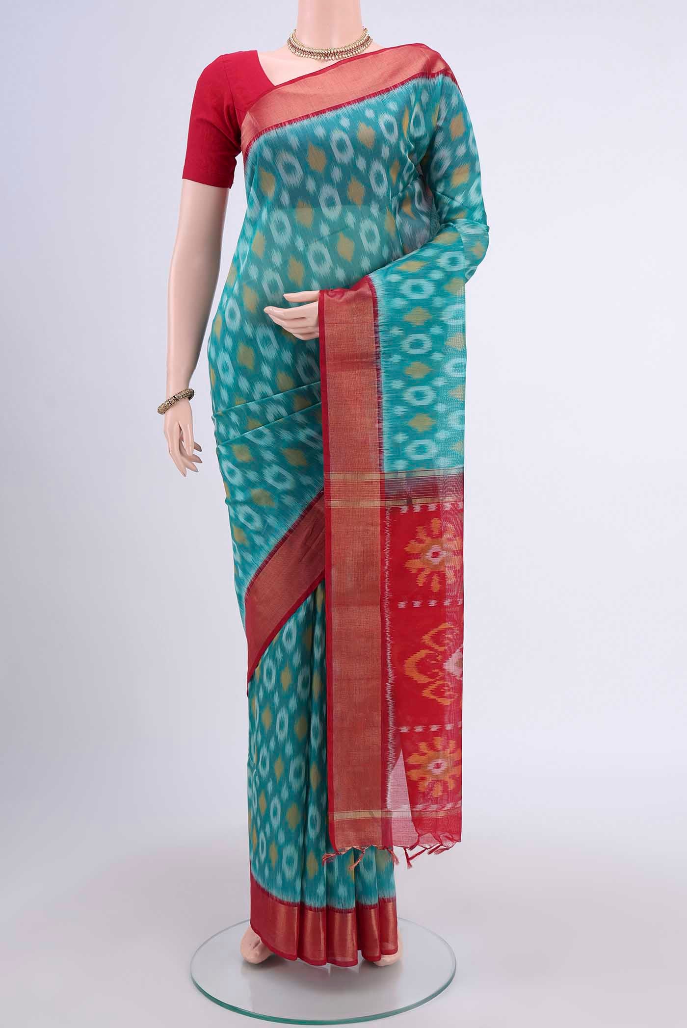 Sea Green Kora Cotton Saree with Ikat design on the body and Zari Border displayed on a mannequin