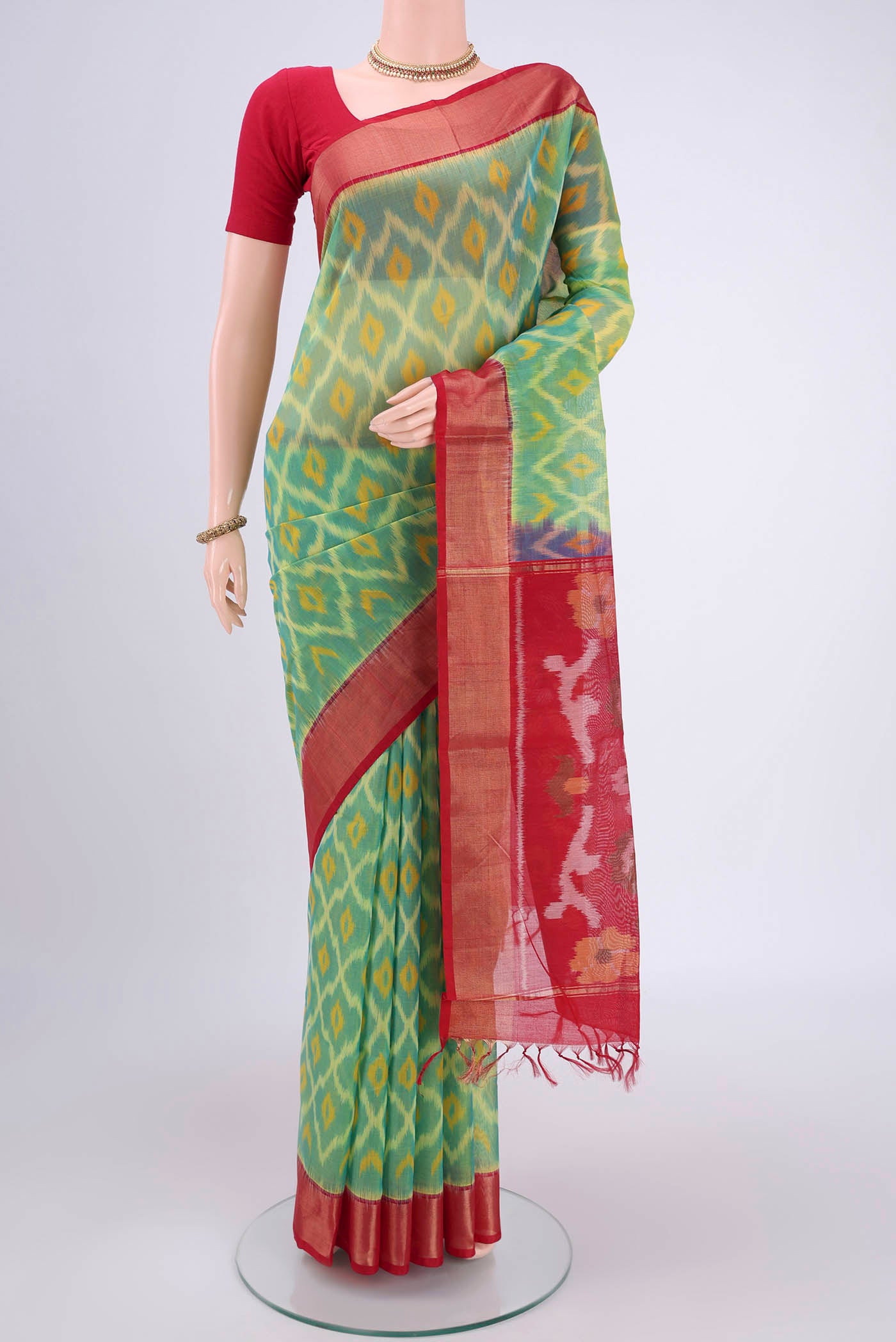 Acid Green Silk Cotton Saree with Ikat design on the body and Zari Border.  displayed on a mannequin