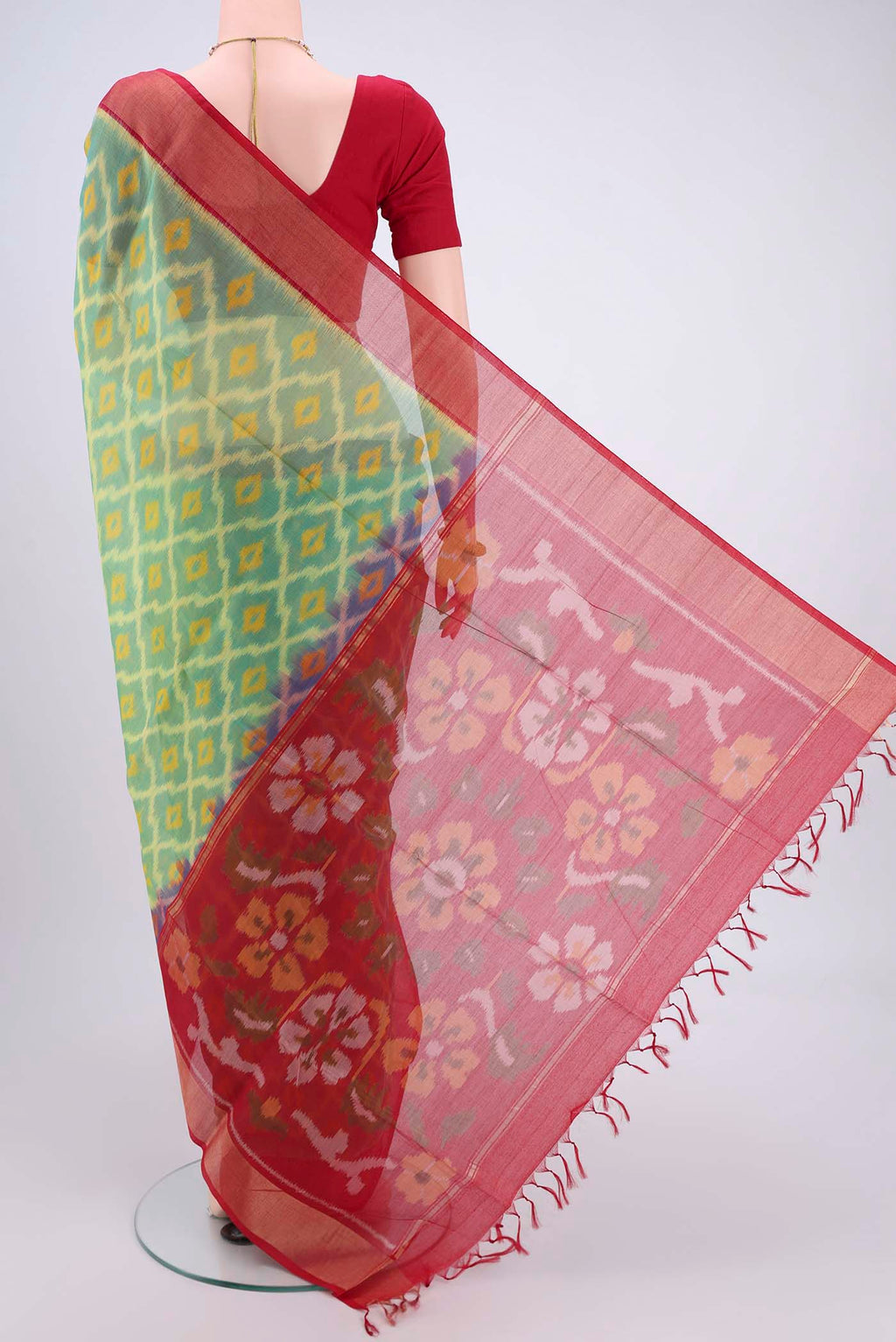 Flat view of Acid Green Silk Cotton Saree with Ikat design on the body and Zari Border. 