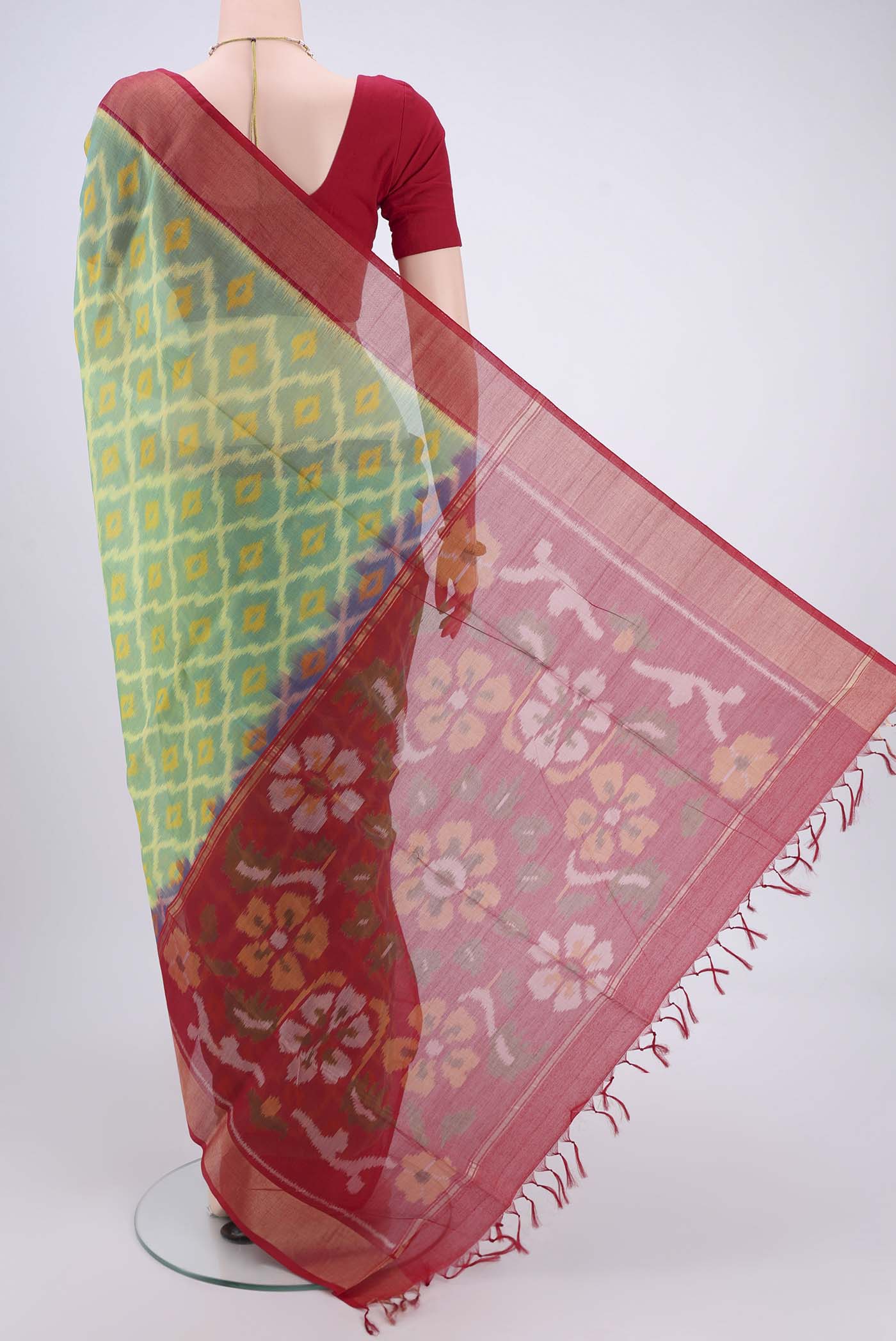 Flat view of Acid Green Silk Cotton Saree with Ikat design on the body and Zari Border. 