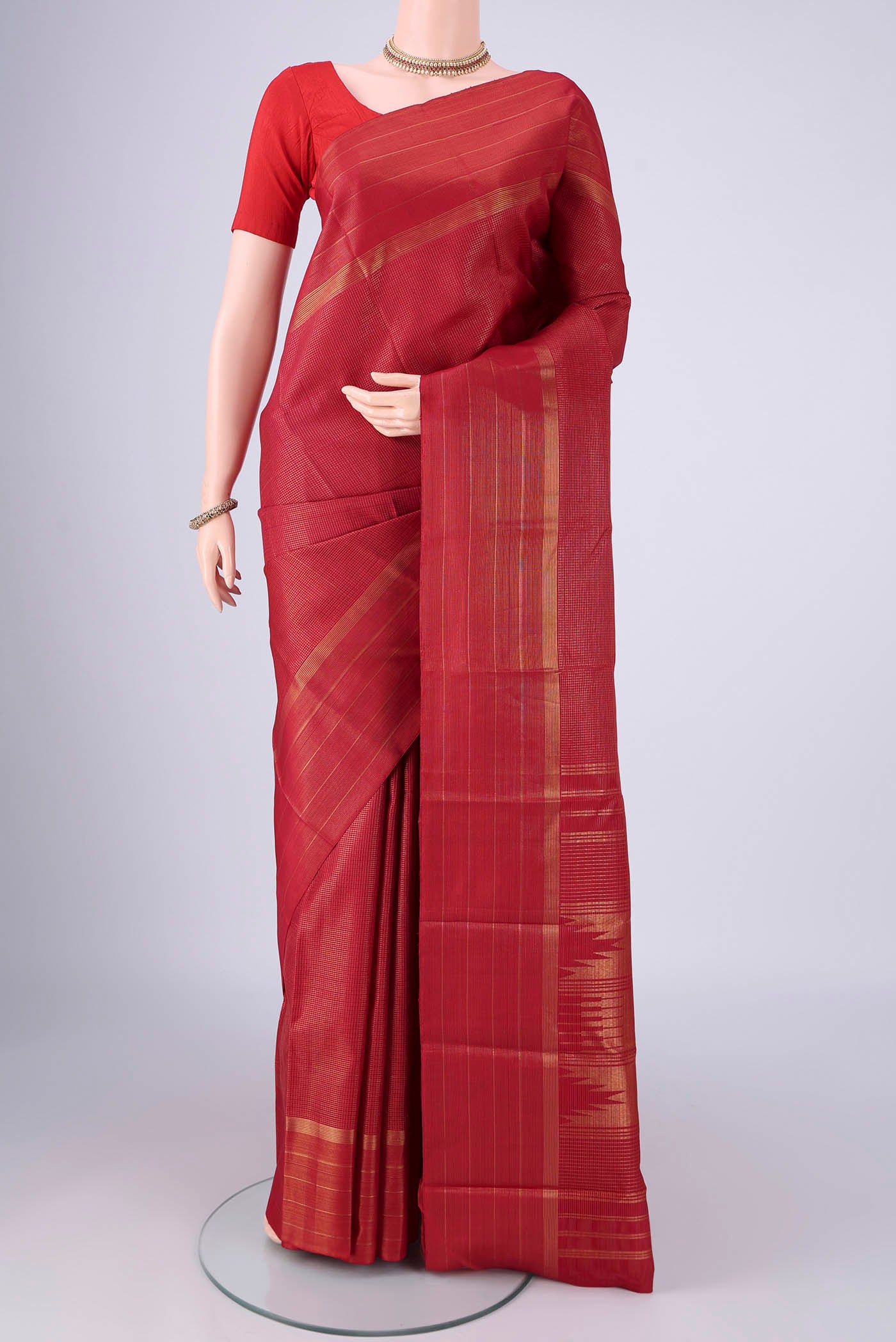 Maroon Kanchipuram Silk Saree with Checked design on the body and Zari Border.  displayed on a mannequin