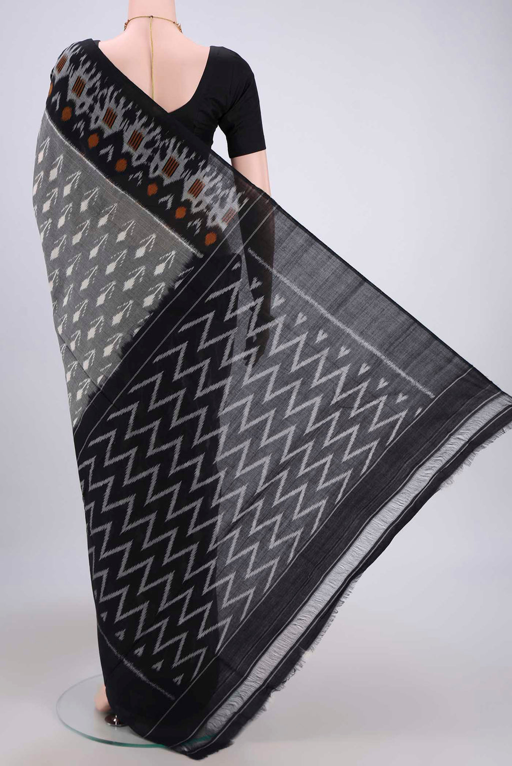 Flat view of Grey Pochampally Cotton Saree with Ikat design on the body and Ikat Border. 