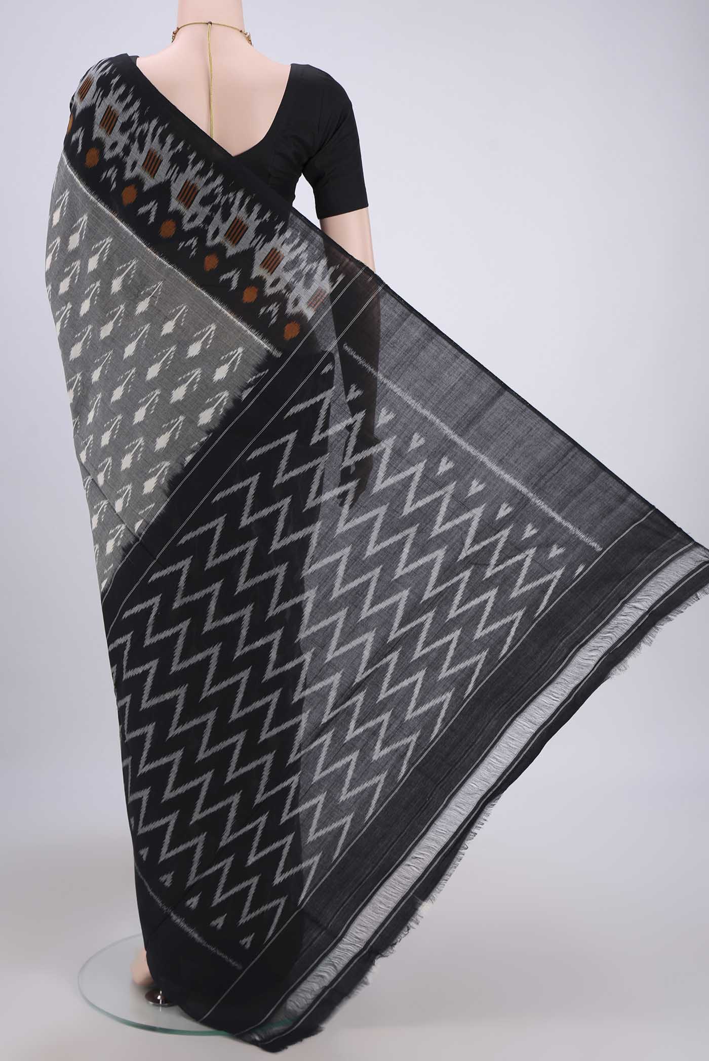 Flat view of Grey Pochampally Cotton Saree with Ikat design on the body and Ikat Border. 