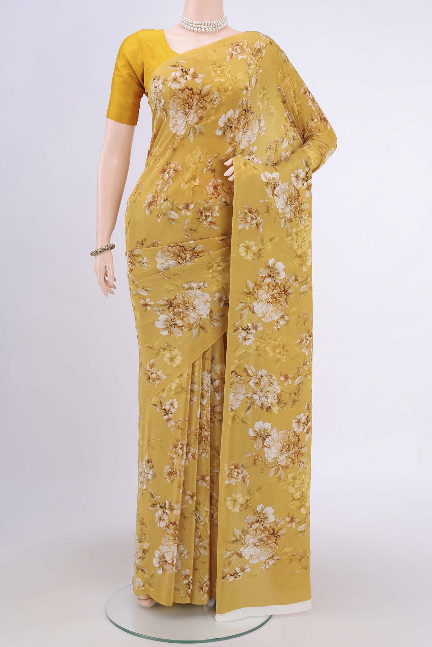 Mustard Crepe Saree with Floral Print on the body and Plain Border.  displayed on a mannequin