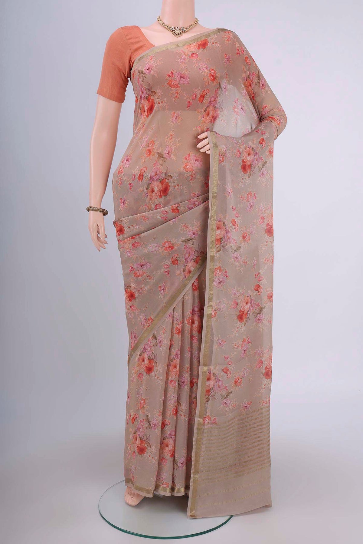 Dark Beige Crepe Saree with Floral Print on the body and Zari Border.  displayed on a mannequin