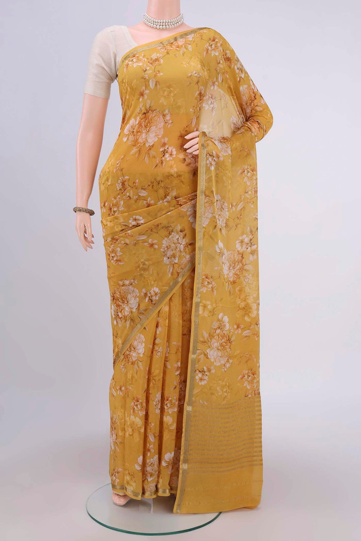 Mustard Crepe Saree with Floral Print on the body and Zari Border.  displayed on a mannequin