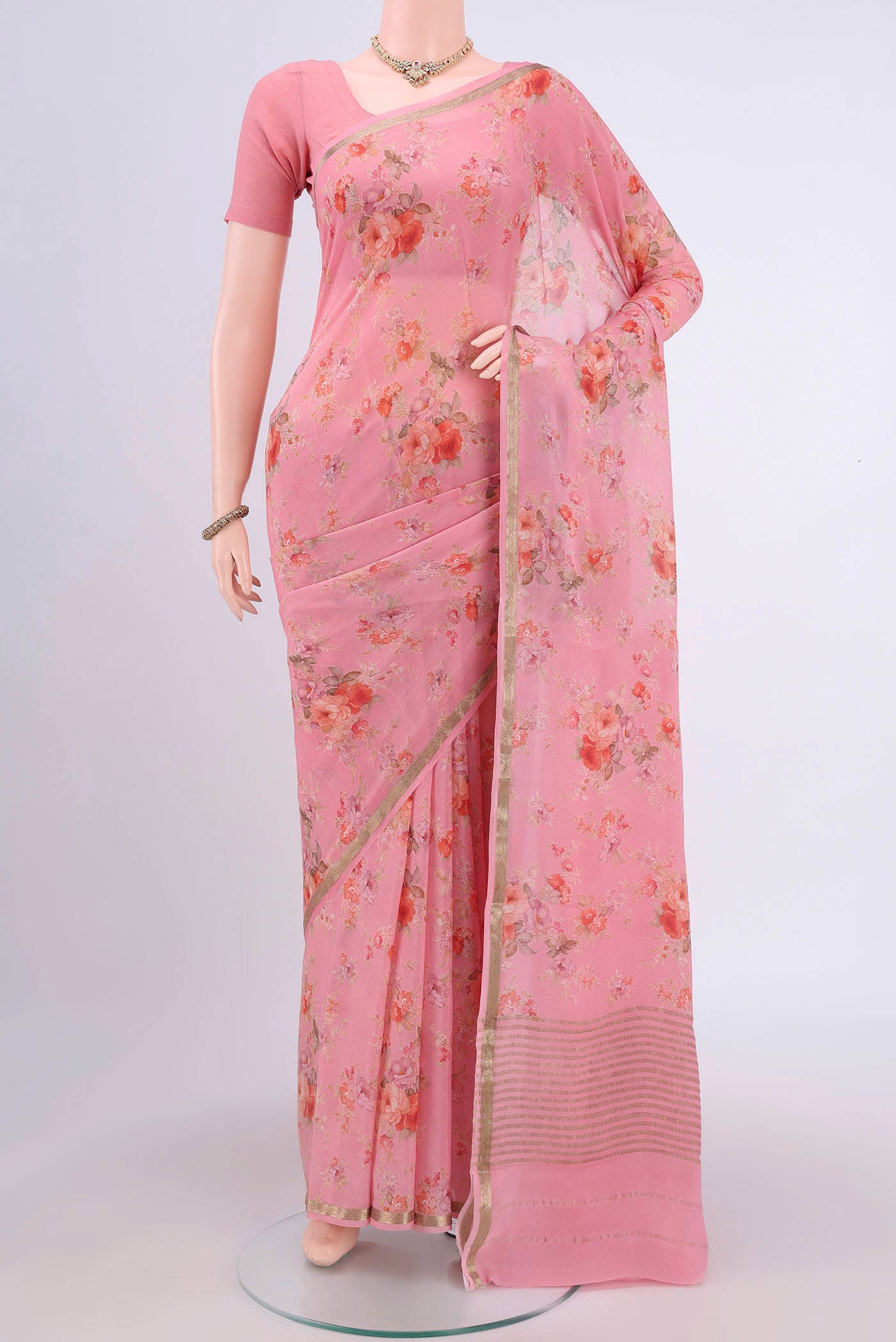 Peach Crepe Saree with Floral Print on the body and Plain Border.  displayed on a mannequin
