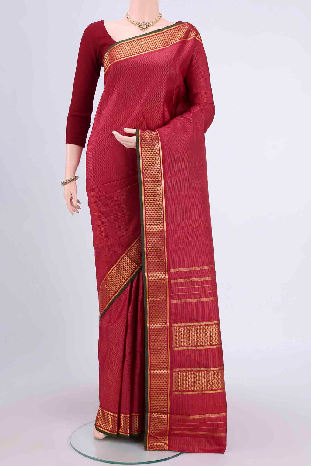Maroon Kanchipuram Saree with Stripes on the body and Zari Border.  displayed on a mannequin