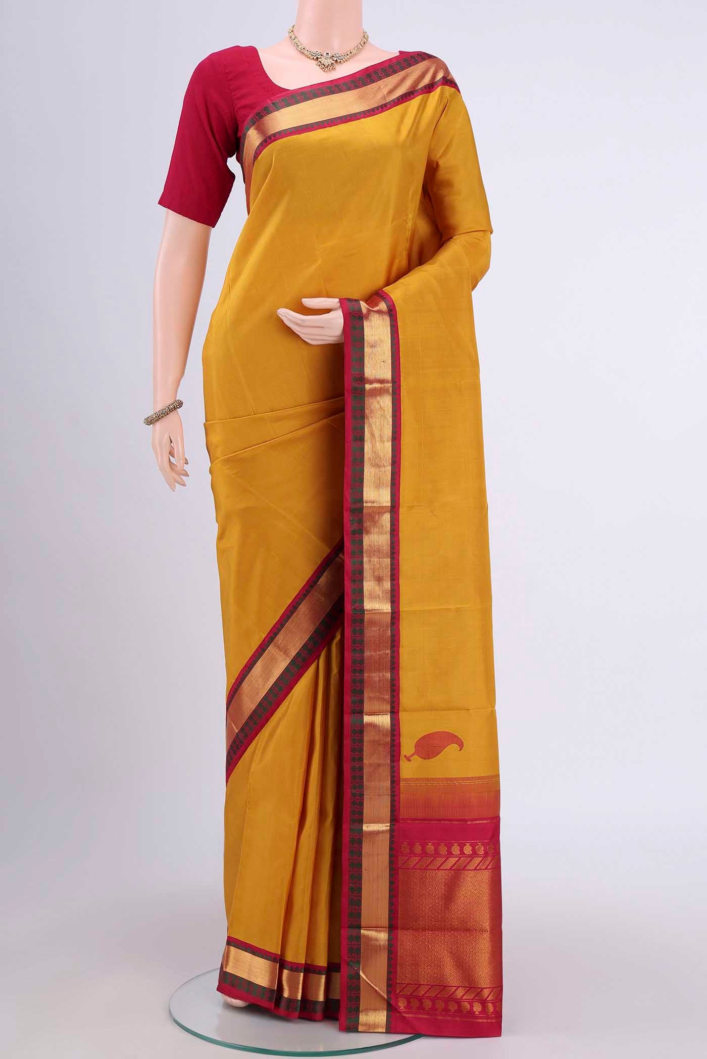 Yellow Kanjivaram Saree with Plain Body and Zari Border.  displayed on a mannequin