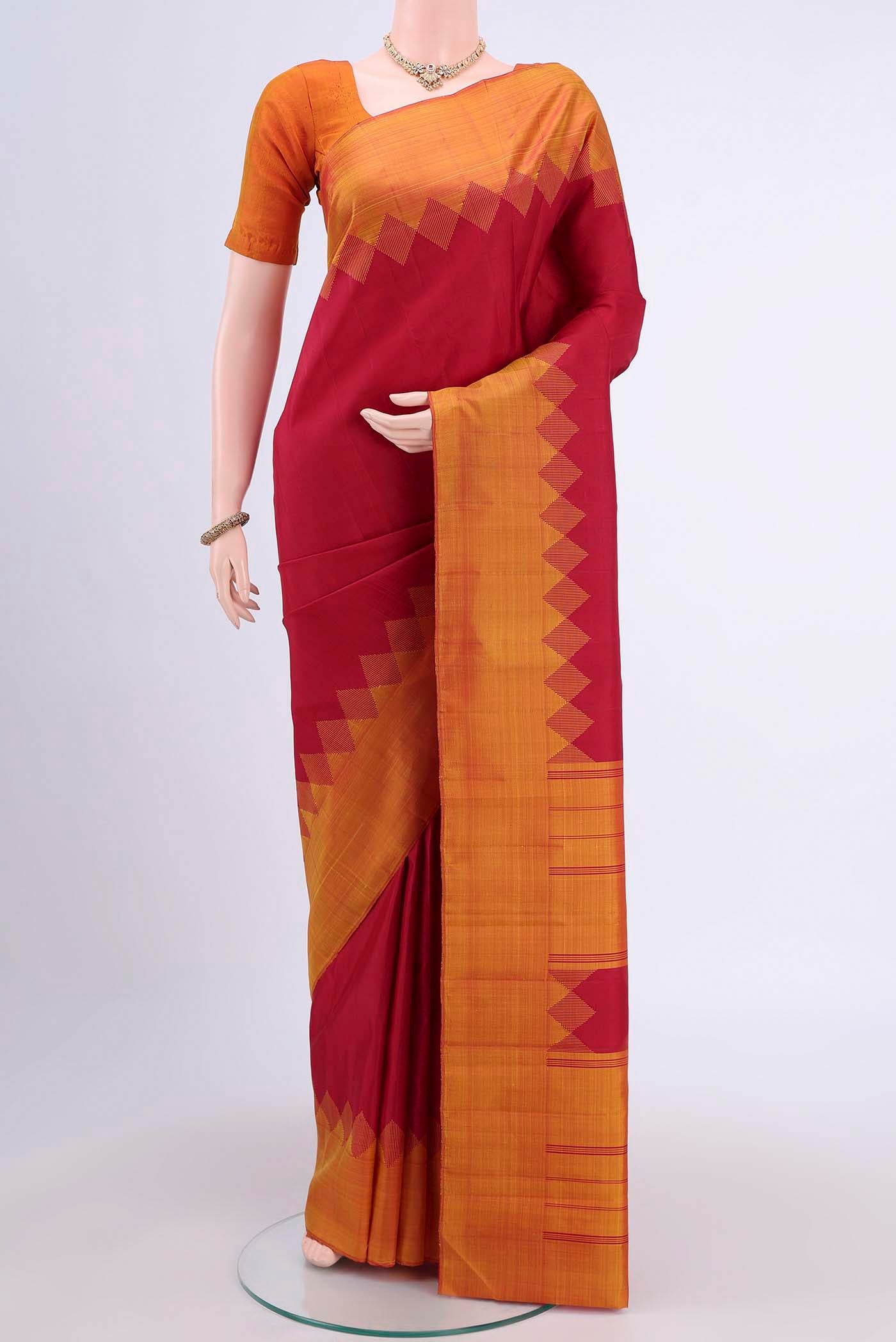 Maroon Kanchipuram Saree with Plain Body and Temple Border displayed on a mannequin