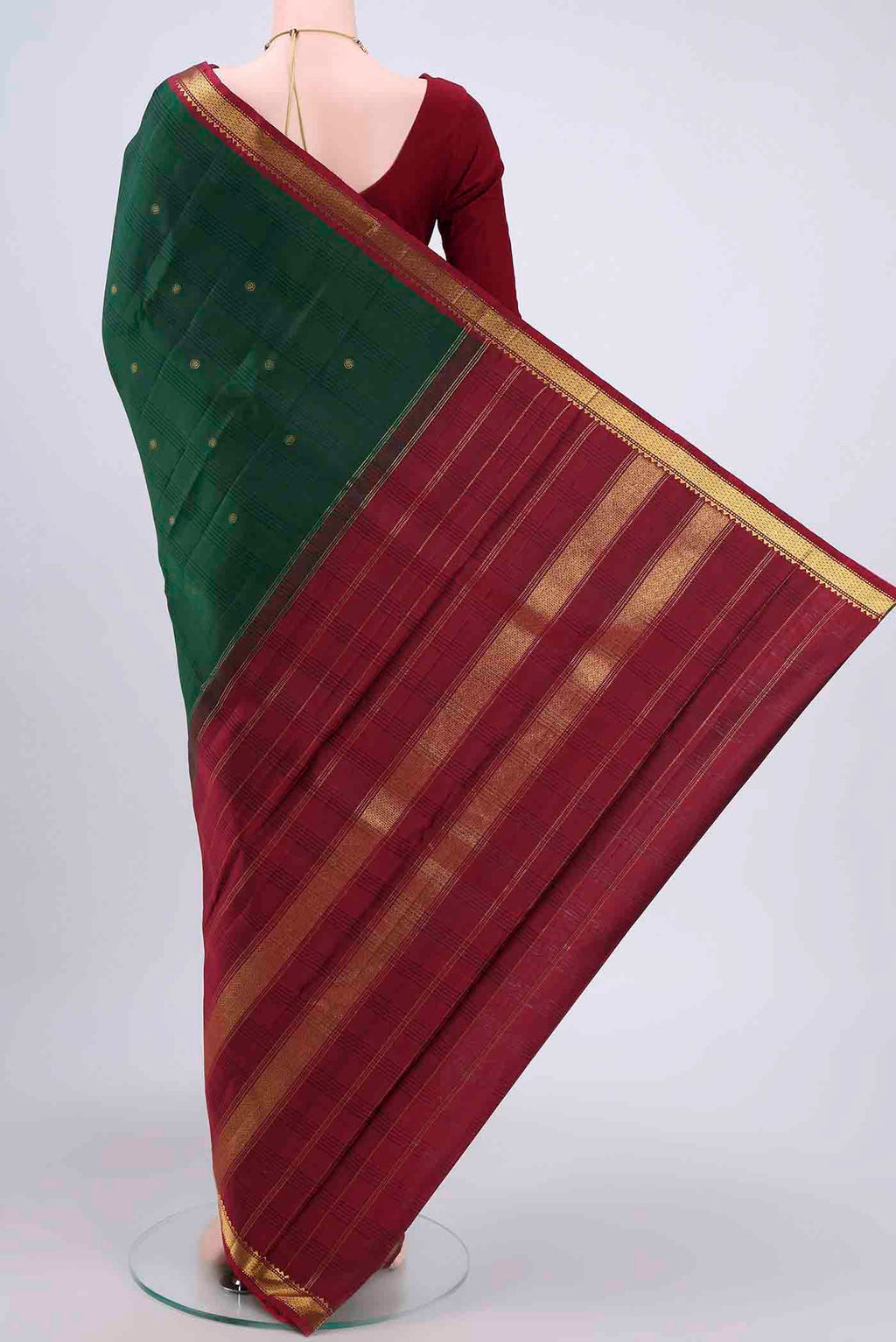 Flat view of Bottle Green Kanchipuram Saree with Zari Butta on the body and Zari Border. 