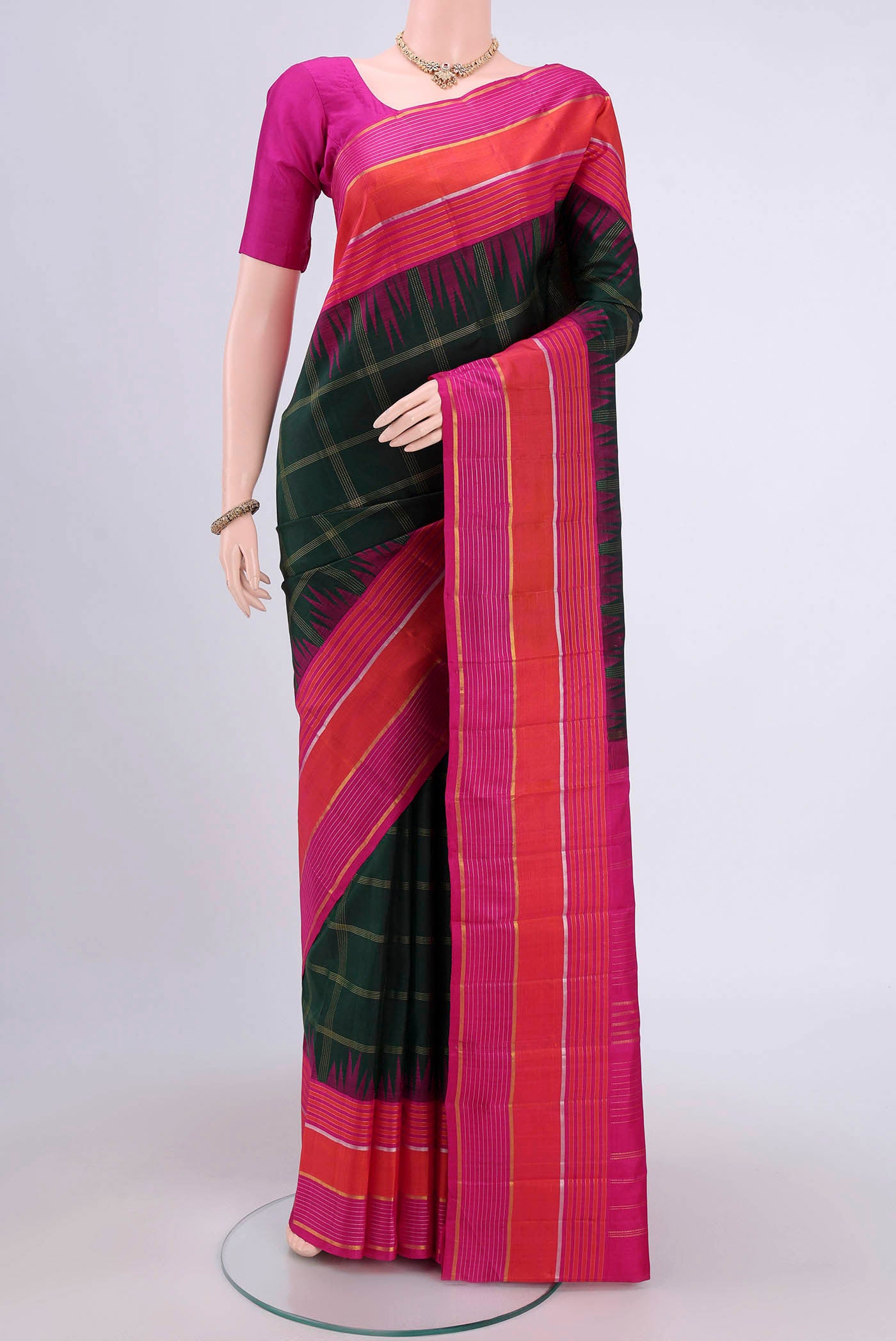 Bottle Green Dual Tone Kanjivaram Saree with Checked design on the body and Zari Border.  displayed on a mannequin
