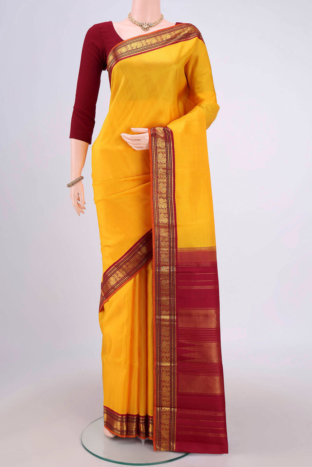 Yellow Kanjivaram Silk Saree with Plain Body and Zari Border.  displayed on a mannequin