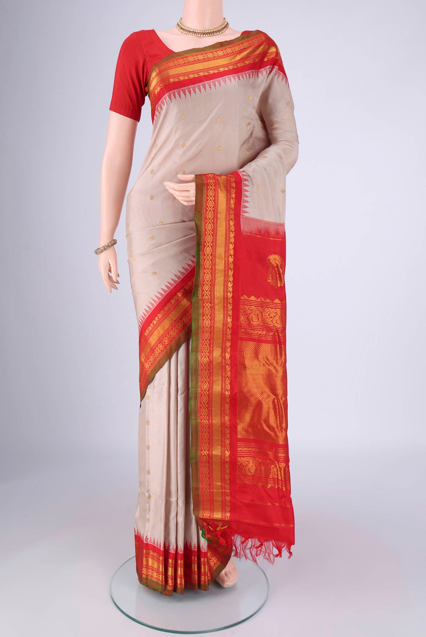 Beige Gadwal Silk Saree with Zari Butta on the body and Zari Border.  displayed on a mannequin